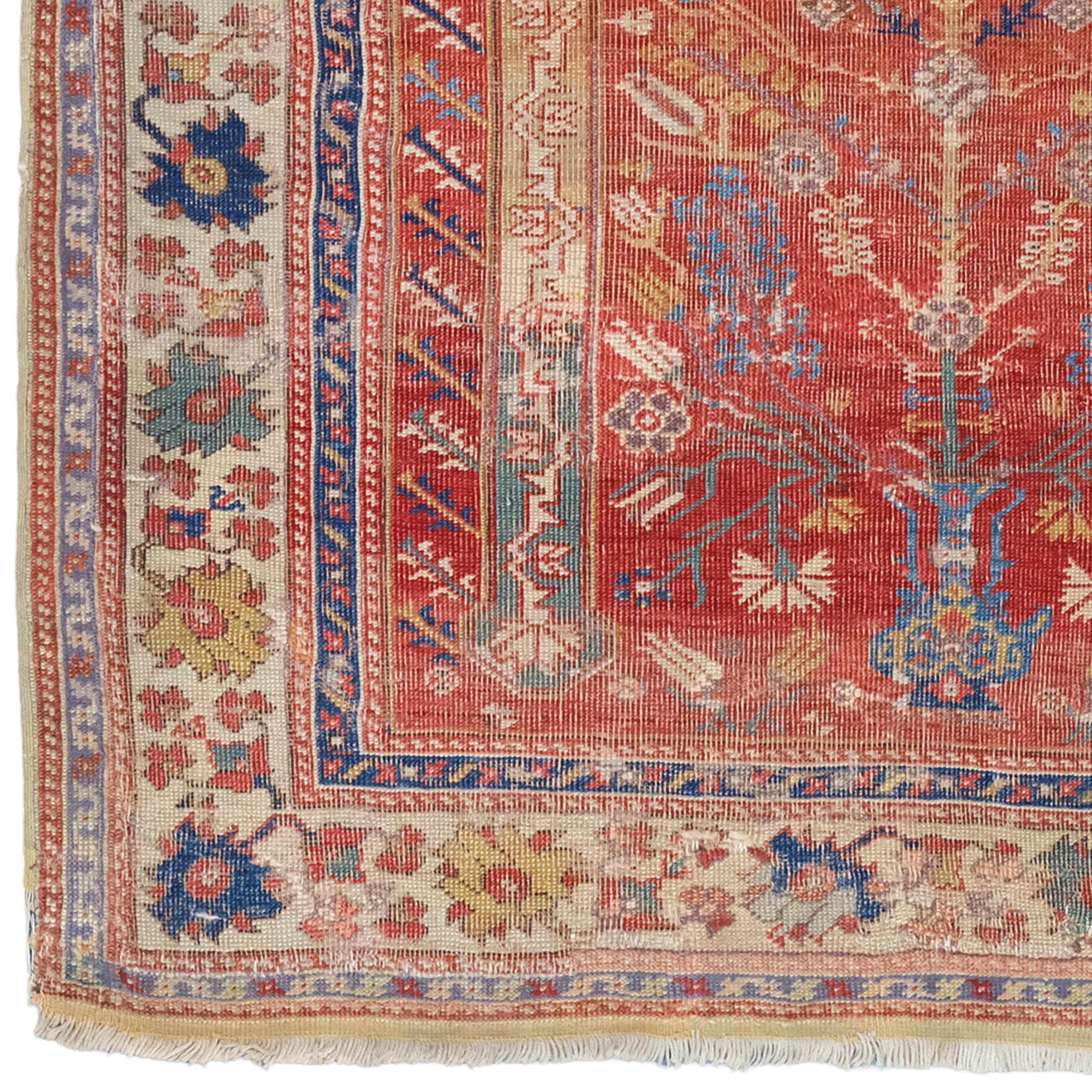 Ce tapis antique Kula est une pièce rare et précieuse du 18e siècle. Le tapis est décoré de motifs géométriques et floraux complexes dans de riches tons de rouge, de bleu et de crème. Dans la partie centrale, des motifs de fleurs et de feuilles