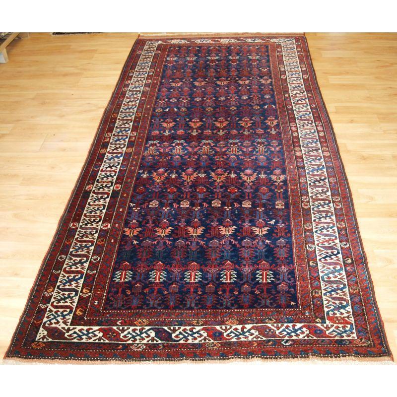 Antique Kurdish kelleh long rug with dragon border.

A very good quality rug with excellent colour, the rug is very well drawn with an all over repeat design of shrubs and small birds. The main border is an outstanding feature of this rug being a