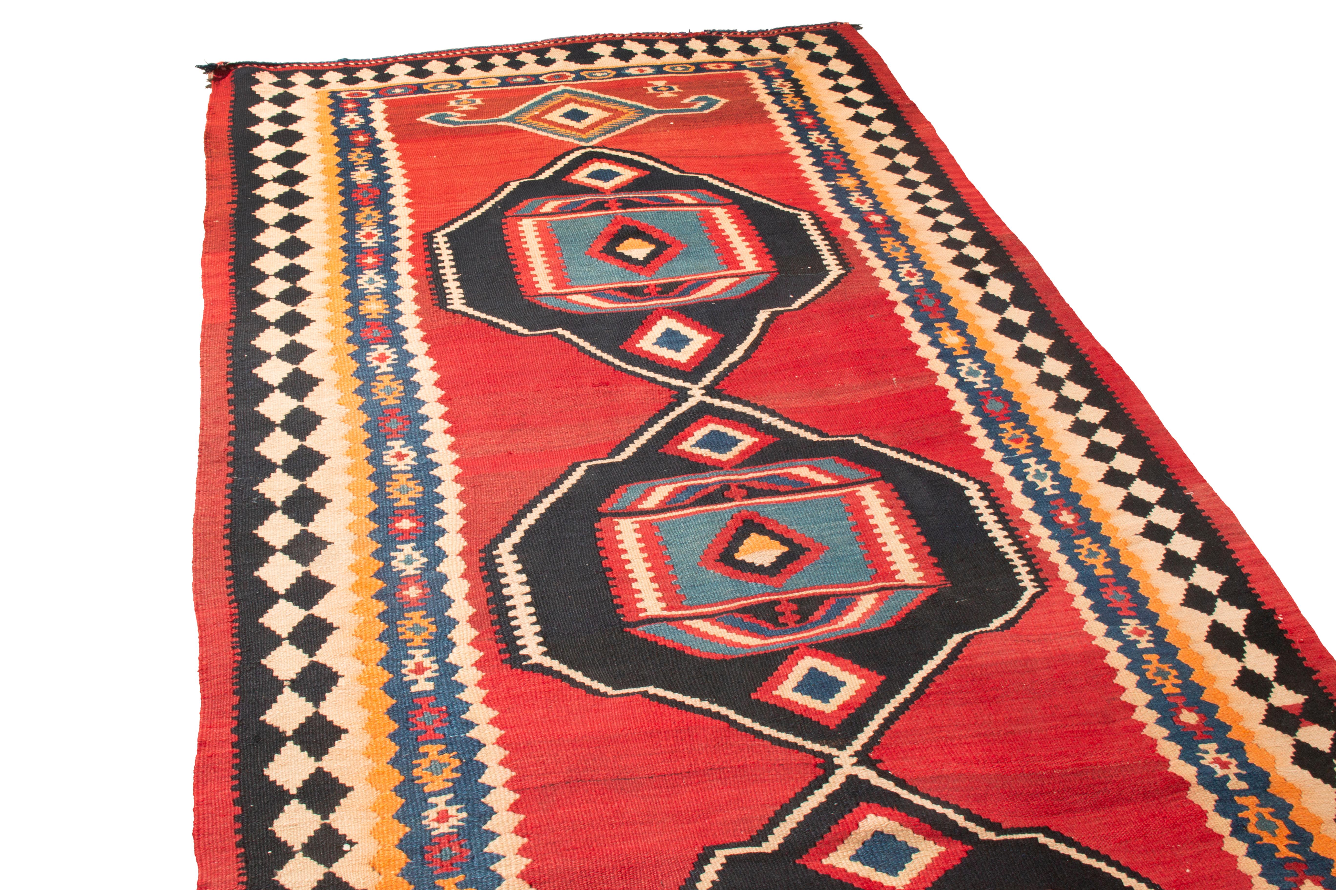 Originating from Persia in 1900, this antique turn of the century Kurdish Kilim rug from Rug & Kilim employs an uncommon combination of several iconic Persian symbols. While the vertical field design. flat-woven in high quality wool, the four