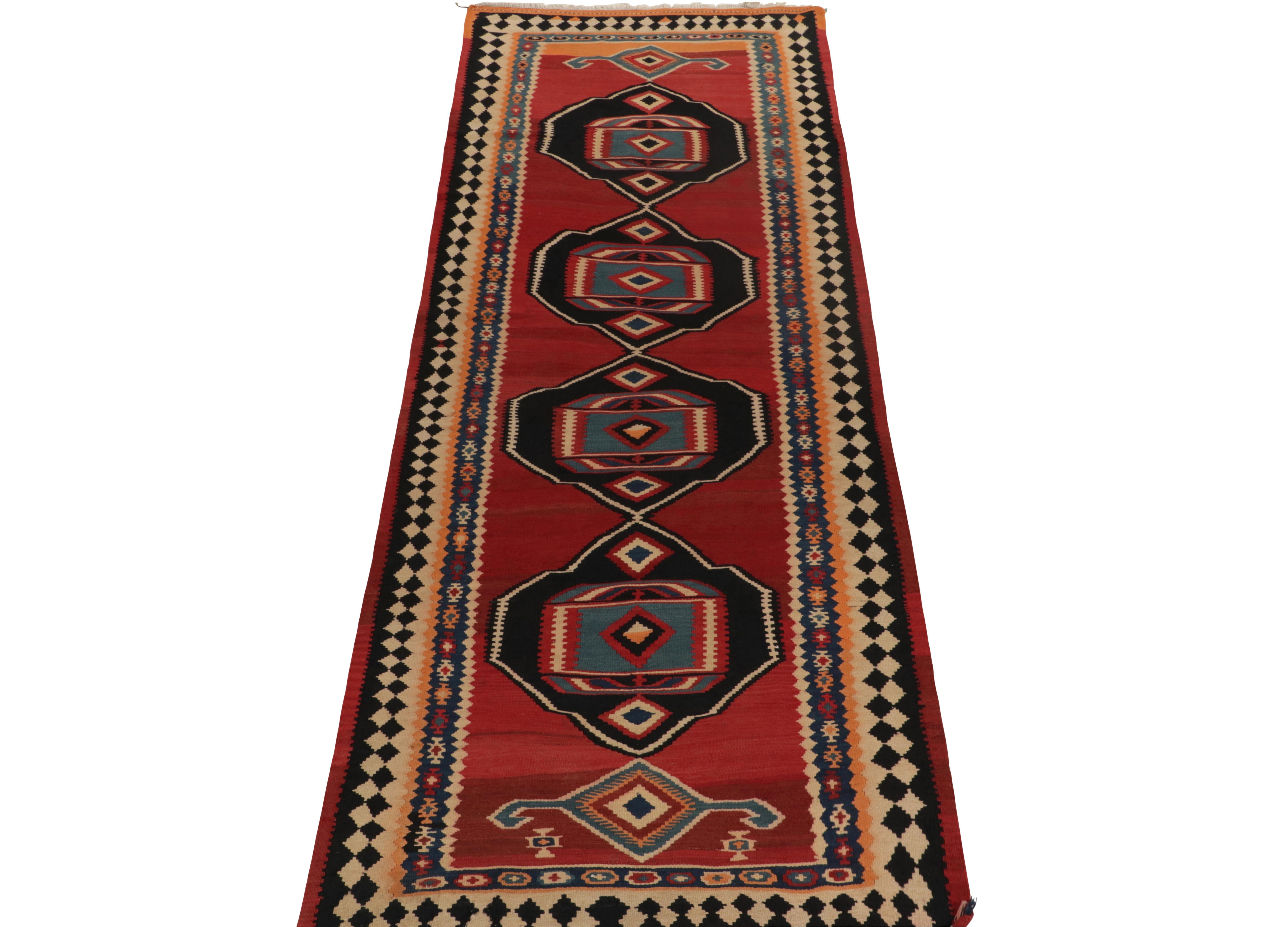 Handwoven in wool, a vintage Kurdish Kilim unveiled from R&K Principal Josh Nazmiyal’s coveted treasury of Persian masterpieces. 

Originating circa 1950-1960, this particular 4x12 tribal rug features a rich play of pink-red, black, beige & blue