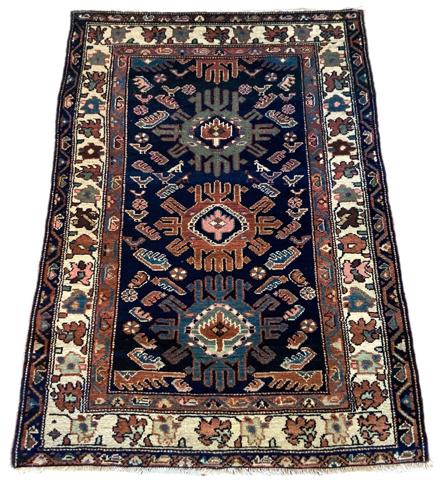 A fab little antique Kurdish rug, handwoven circa 1920 with a slightly random design of stylised symbols and figures on a deep indigo field and ivory border. Lovely secondary colours of greens, blues and golds.
Size: 1.34m x 0.95m (4ft 5in x 3ft