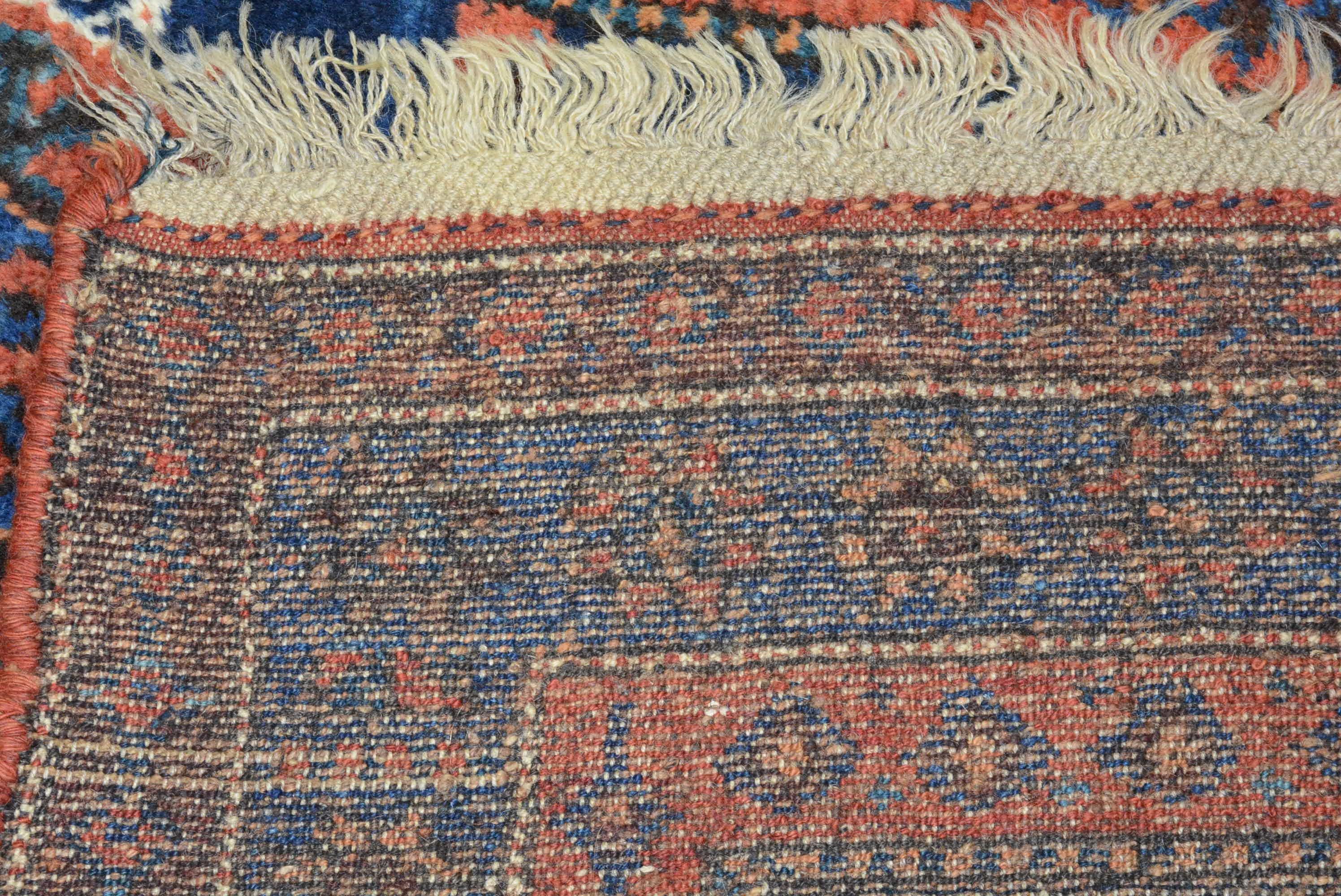This antique Kurdish rug from western Persia was woven in the late 19th century. The repeat pattern of hexagonal medallions on the indigo field are filled with stylized animal heads that were inspired by similar patterns utilized by neighboring