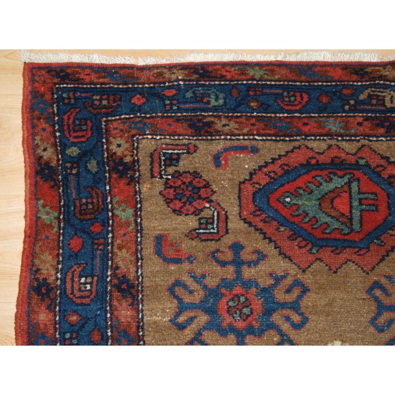 Antique Kurdish rug from the Greater Hamadan region, probably Mehraban district.

The design is most unusual, with the central medallion containing a tree like design. The camel coloured field contains large scale designs.

The colours