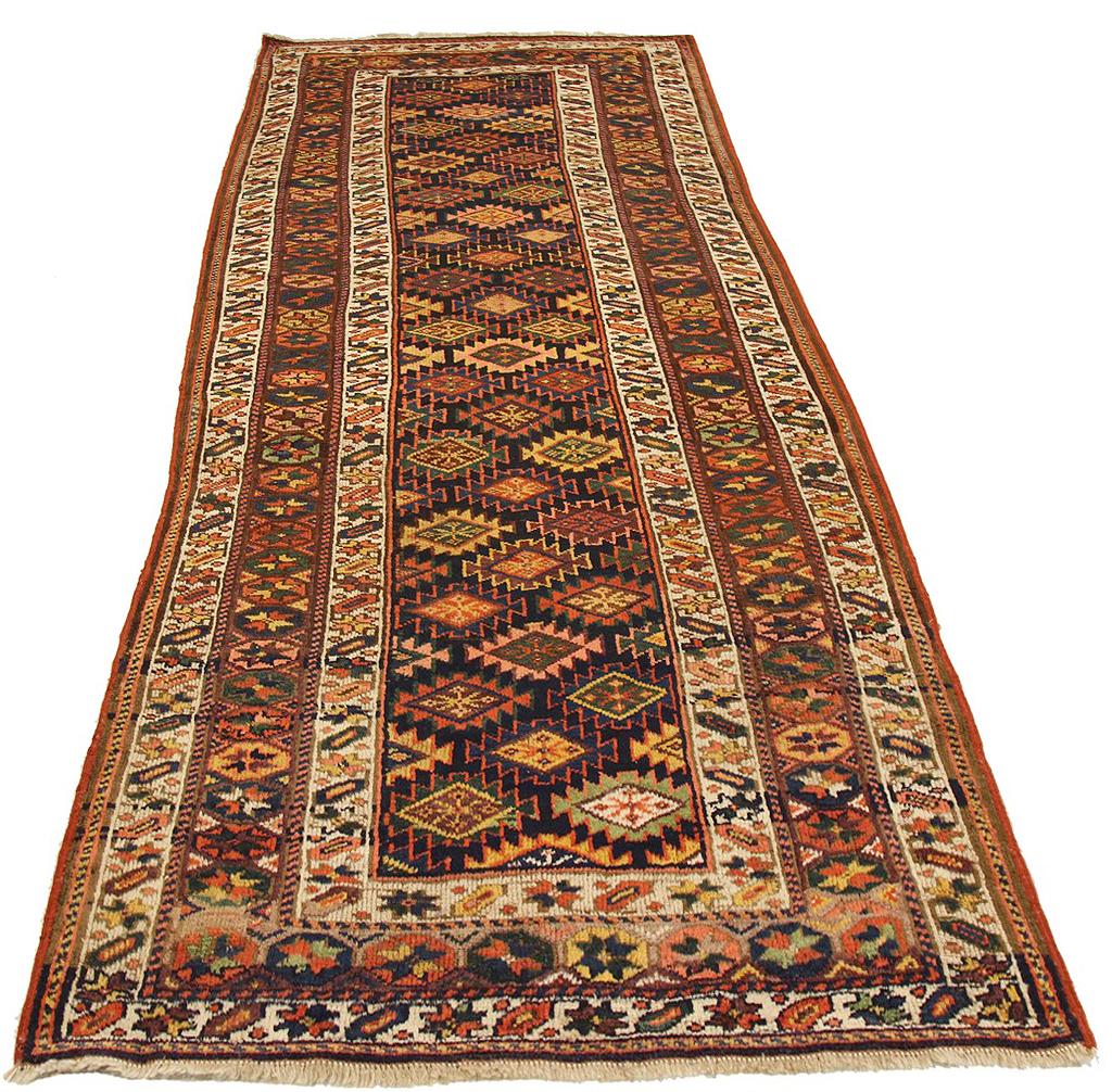 Antique Persian rug handwoven from the finest sheep’s wool and colored with all-natural vegetable dyes that are safe for humans and pets. It’s a traditional Kurdish design highlighted by large and small geometric medallions in navy and green over a