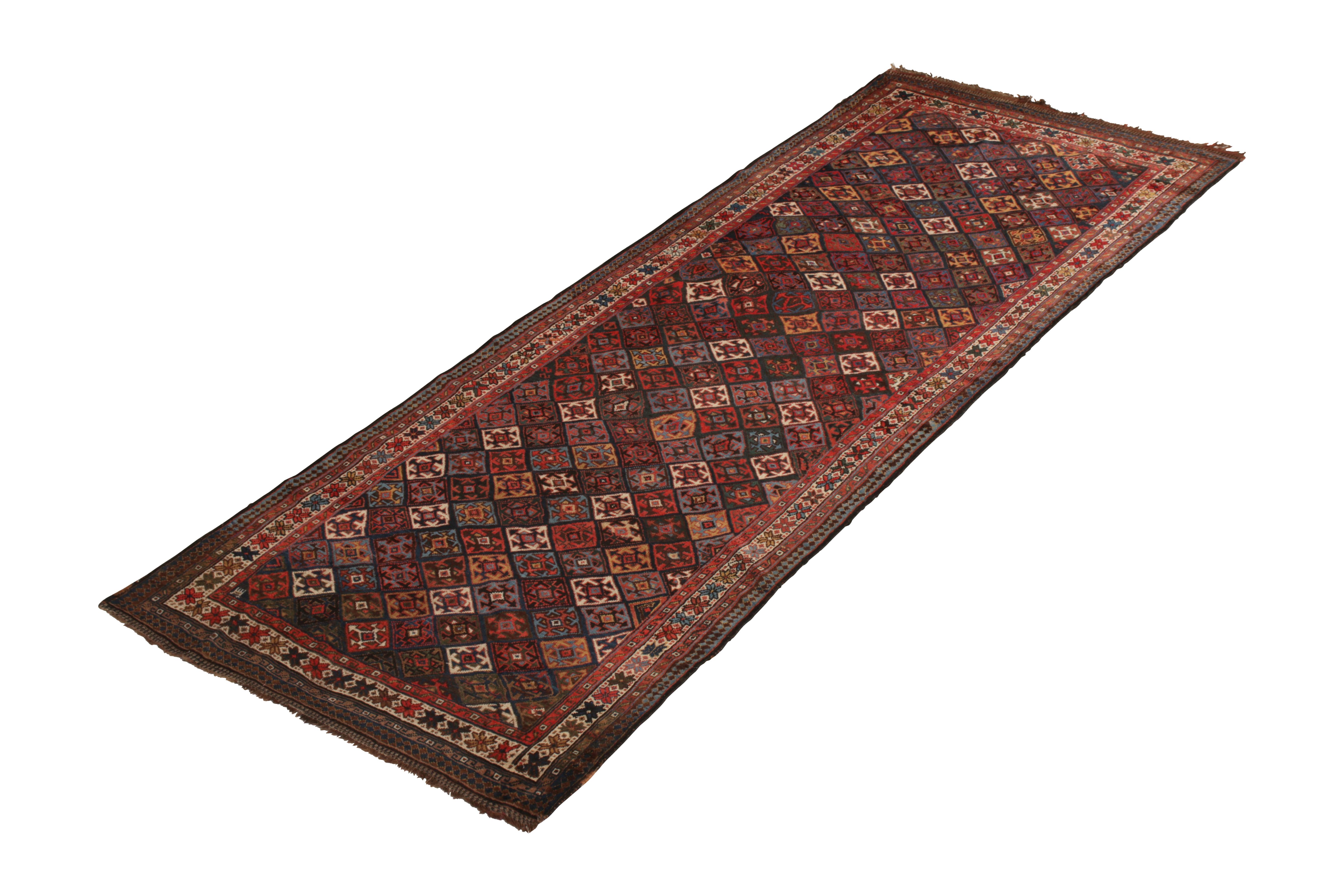 Hand knotted in wool originating from Persia circa 1890-1900, this antique rug enjoys the subtle distinction of the Kudish rug design, remarked in no small part in this approach to multicolor accents against the prevailing crimson red and