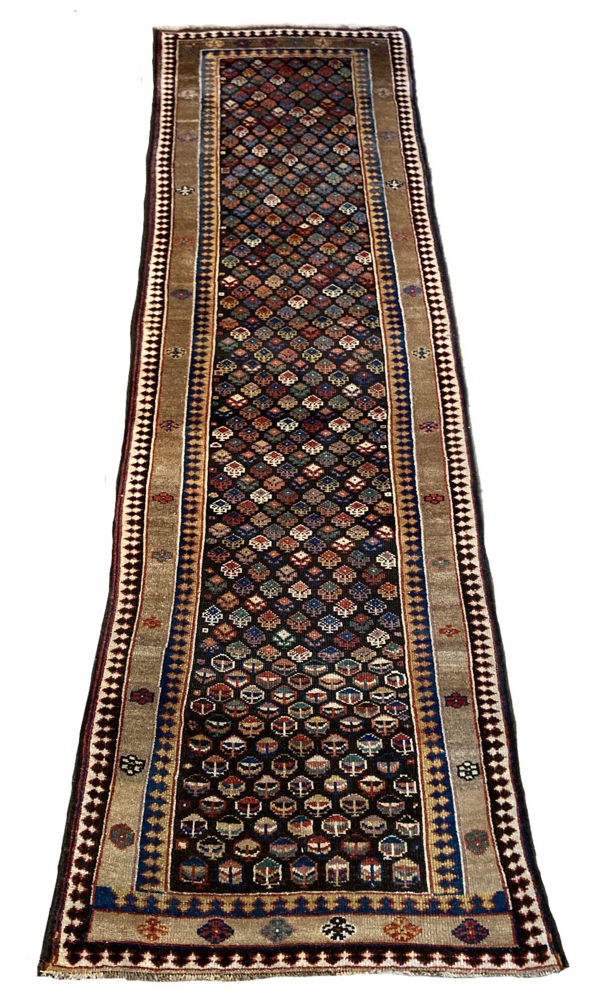 A fabulous antique Kurdish runner, hand woven circa 1900. The design features an all over geometrical design on a deep chocolate field encased by a simple camel coloured border. Lovely wool quality and great secondary colours of blues, greens, golds