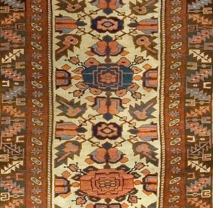 Antiker kurdischer Läufer 3'7 x 13'5. Ein angenehmes, in leuchtenden Farben gewebtes Blumenmuster spielt über dem elfenbeinfarbenen Mittelfeld. Eine Bordüre mit vier Reihen geometrischer Blumen- und Weinrankenmuster in Braun-, Blau-, Violett- und