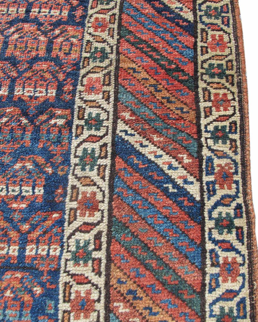 Antique Northwest Persian Kurdish Runner Rug, c. 1900

This long Kurdish runner from Northwest Persia draws rows of ‘boteh’ paisleys in shades of madder-red with gold and white highlights across an indigo-blue field. With any repeat design of this