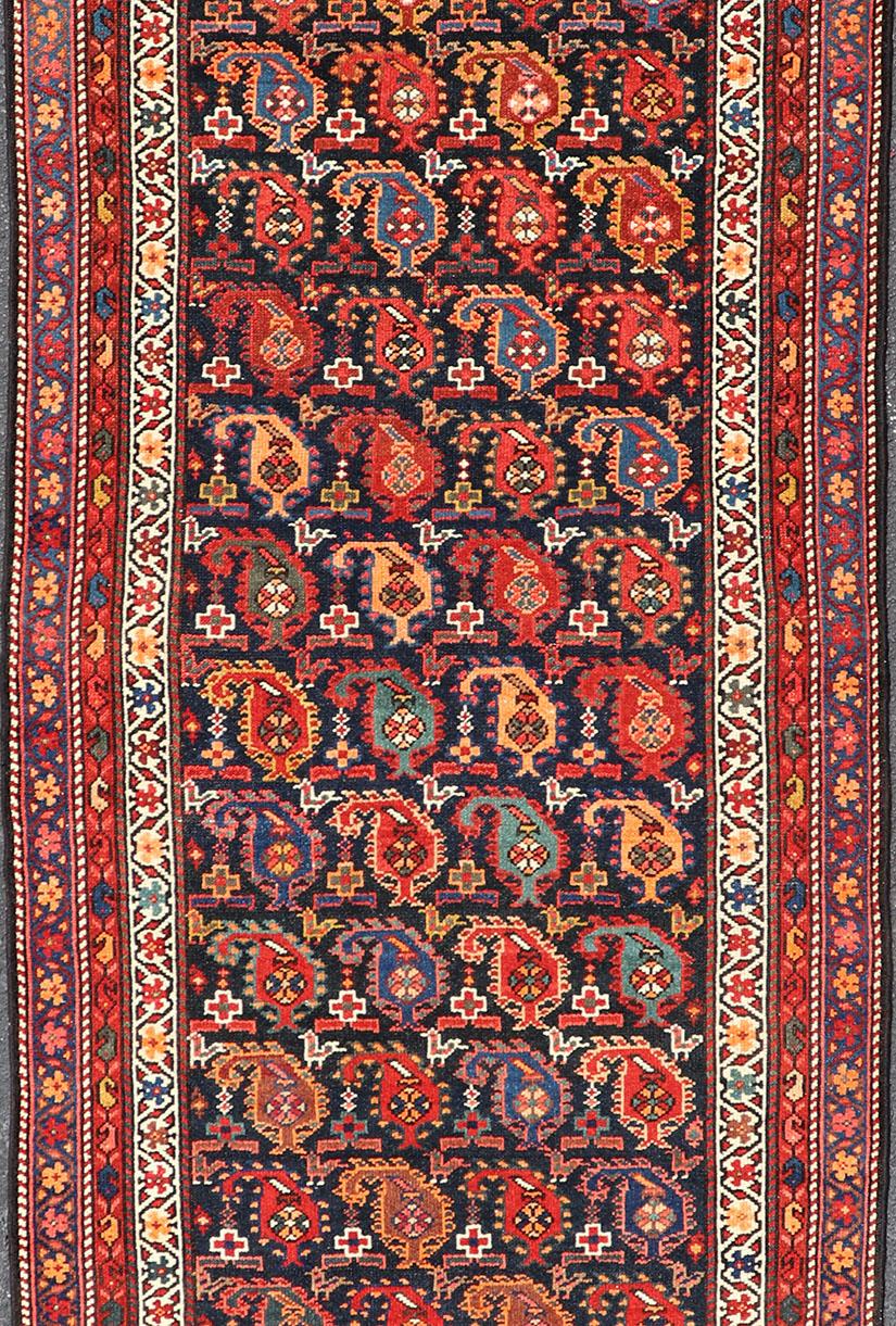 Antique Runner from Persia with geometric design in charcoal background, with accent colors of red, blue, green, orange and Light blue. Keivan Woven Arts/ rug ZIR-63-KV-16-P13630, country of origin / type: Iran / Kurdish, circa 1910.

This Kurdish