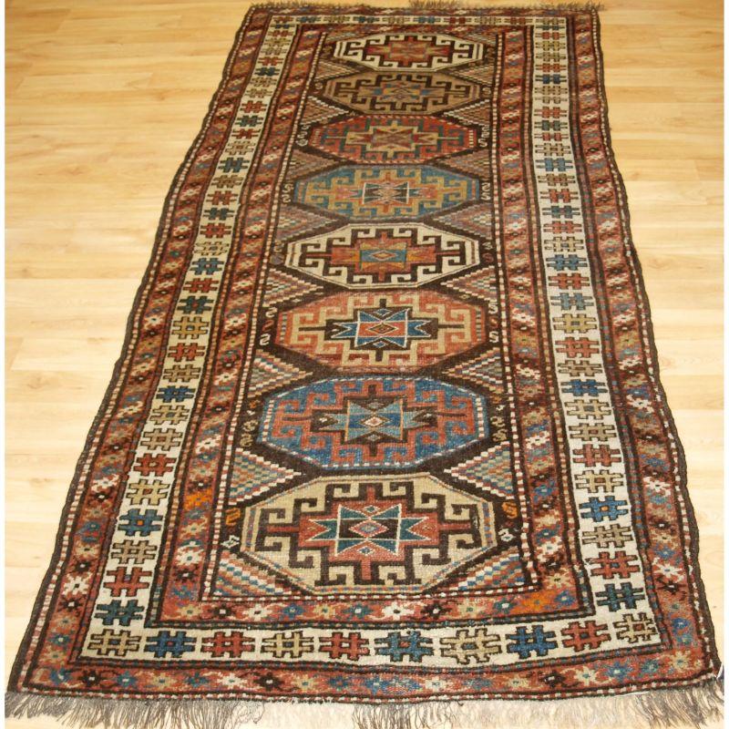 Antique Kurdish runner with Memling gul design.

A good Kurdish runner with eight large Memling guls in soft pastel colours. The runner has a rustic feel, typical of Kurdish village weaving. As is usual with Kurdish village rugs, this one is