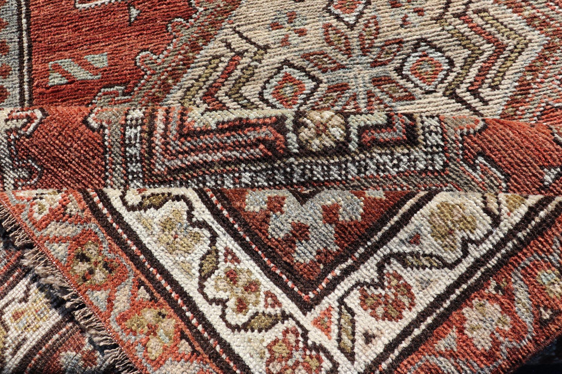 Persian Antique Kurdish Runner with Rusty Red Background and Medallions Tribal Motifs For Sale