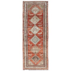 Tapis de couloir kurde ancien avec fond rouge rouille et motifs tribaux à médaillons