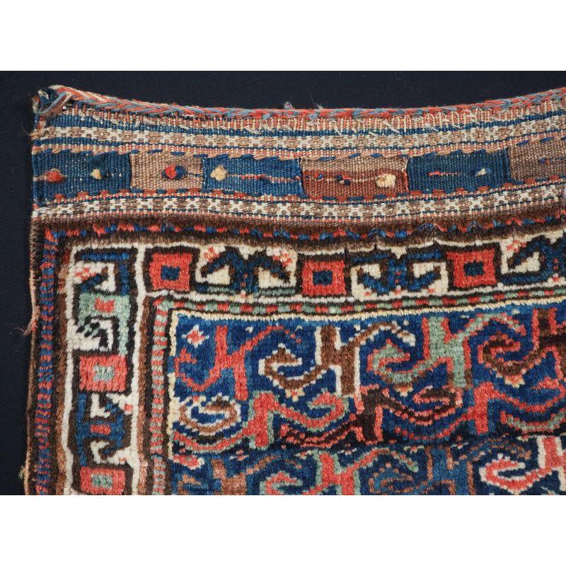 Antique Kurdish saddle bag bag face with very unusual design.
Size: 2ft 2in x 1ft 9in (66 x 54cm).
Circa 1900.

The bag face is drawn with a all over design in soft pastel colours on a indigo blue ground, the border is of a bold design on an ivory