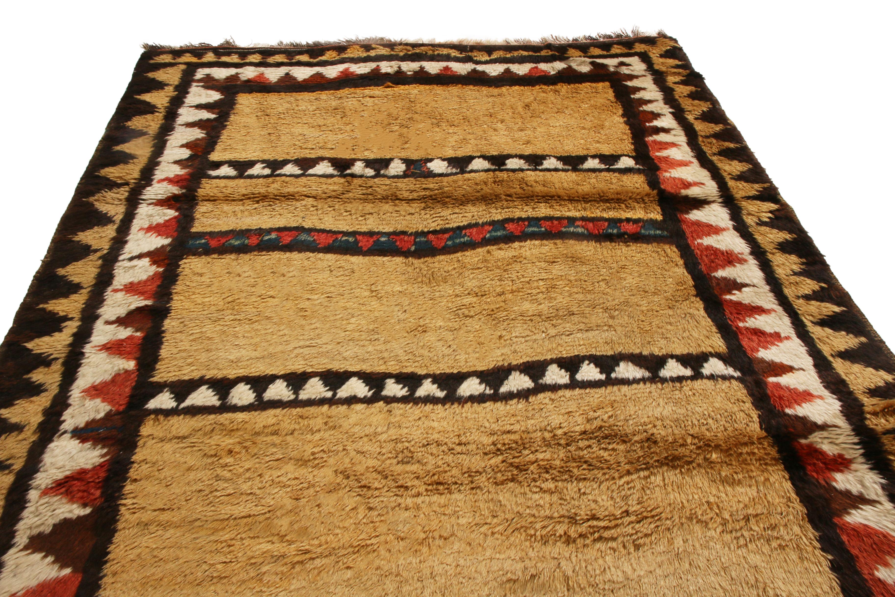 Originating from Russia between 1900-1920, this antique transitional Kurdish rug employs a Minimalist tribal design with mirrored abrash fringes along its vertical width. Hand knotted in lush, high quality wool pile, Kurdish pieces have been known