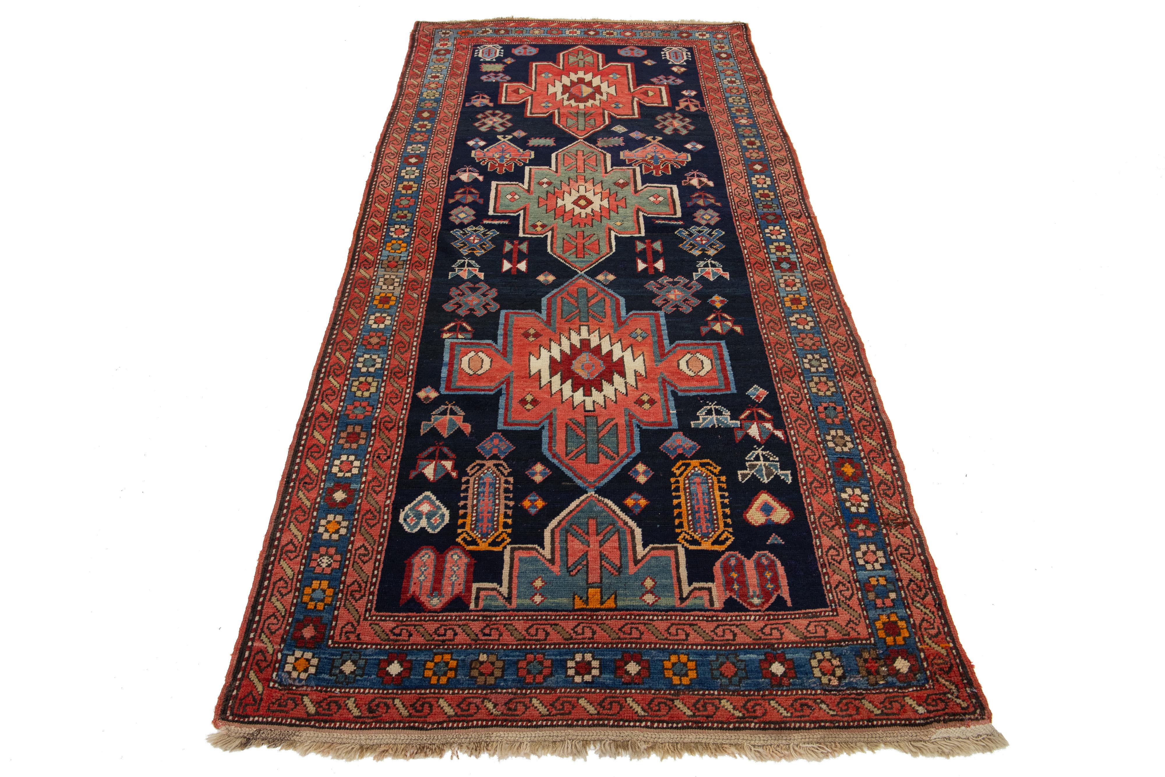 Dieser schöne kurdische handgeknüpfte Wollteppich aus dem 20. Jahrhundert hat ein dunkelblaues und rotes Farbfeld. Es zeigt atemberaubende mehrfarbige Akzente in einem wunderschönen Tribal-Muster.

Dieser Teppich misst 3'11
