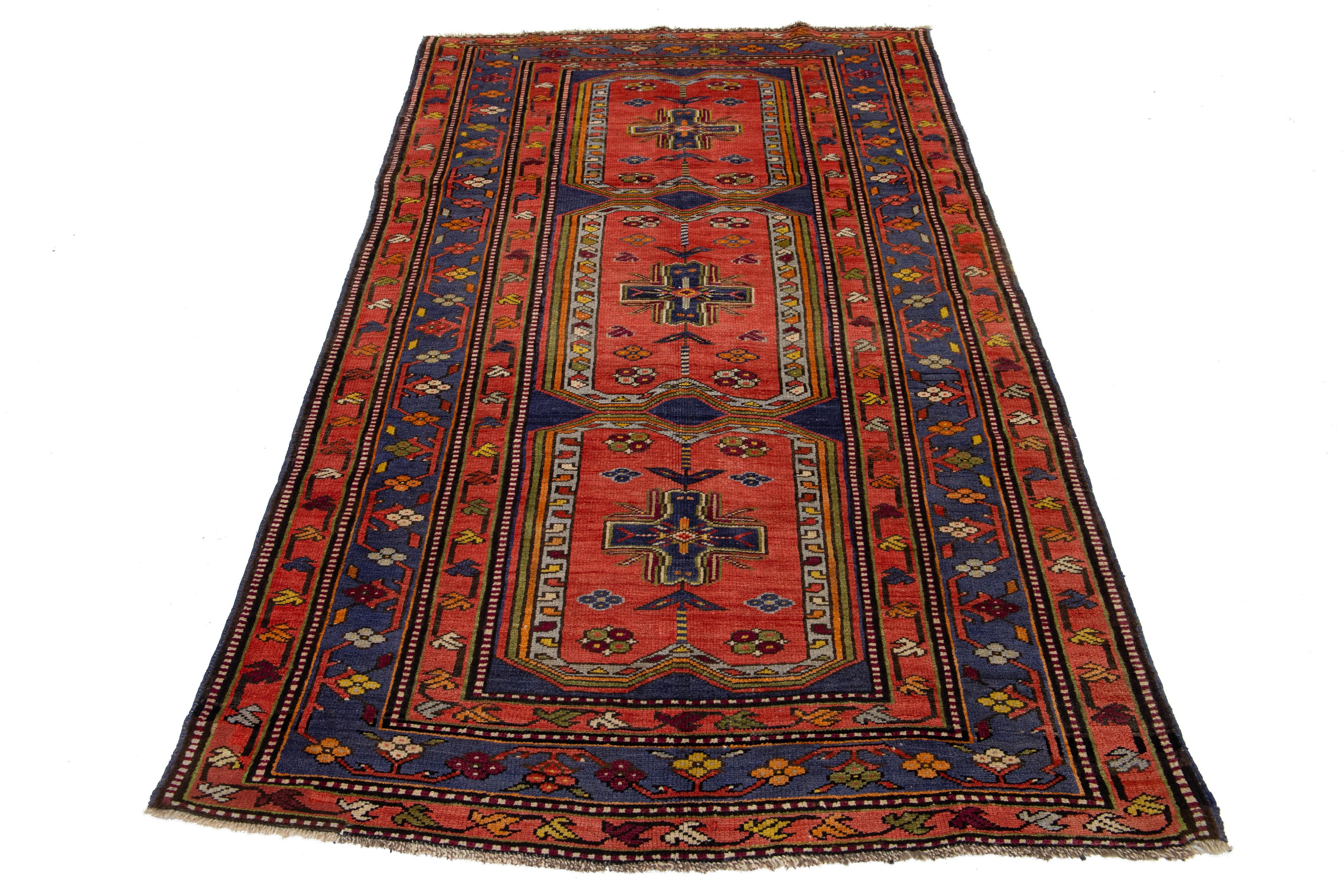 Dieser schöne kurdische handgeknüpfte Wollteppich aus dem 20. Jahrhundert hat ein rotes Farbfeld. Es zeigt atemberaubende mehrfarbige Akzente in einem wunderschönen Tribal-Muster.

Dieser Teppich misst 4'5