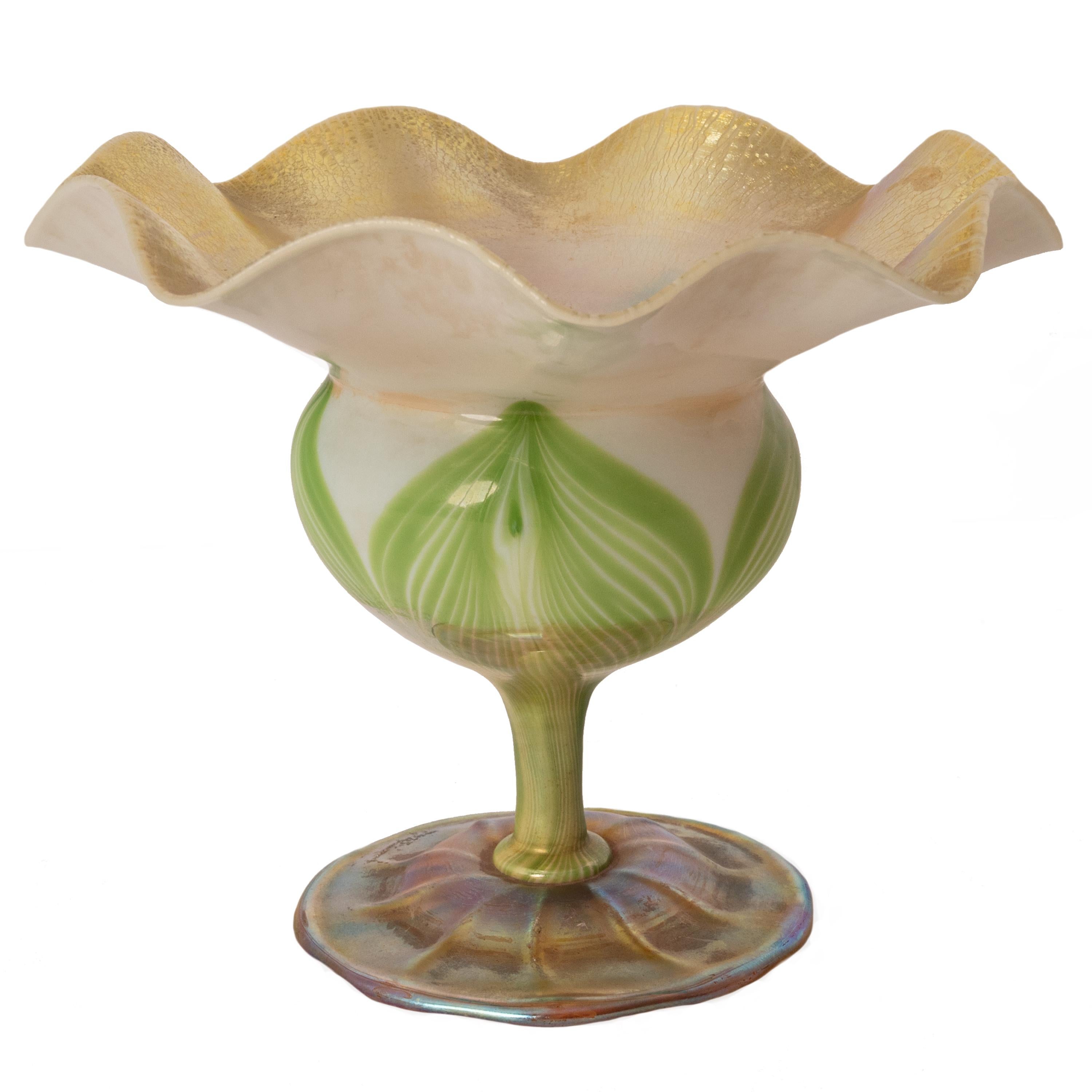 Antique L. C. Tiffany large Favrile iridescent Floriform glass vase, circa 1908.The vase is of larger form than most of this style and handblown with a wavy crimped edge and globular body raised on a stem with a circular ribbed, flared foot. The