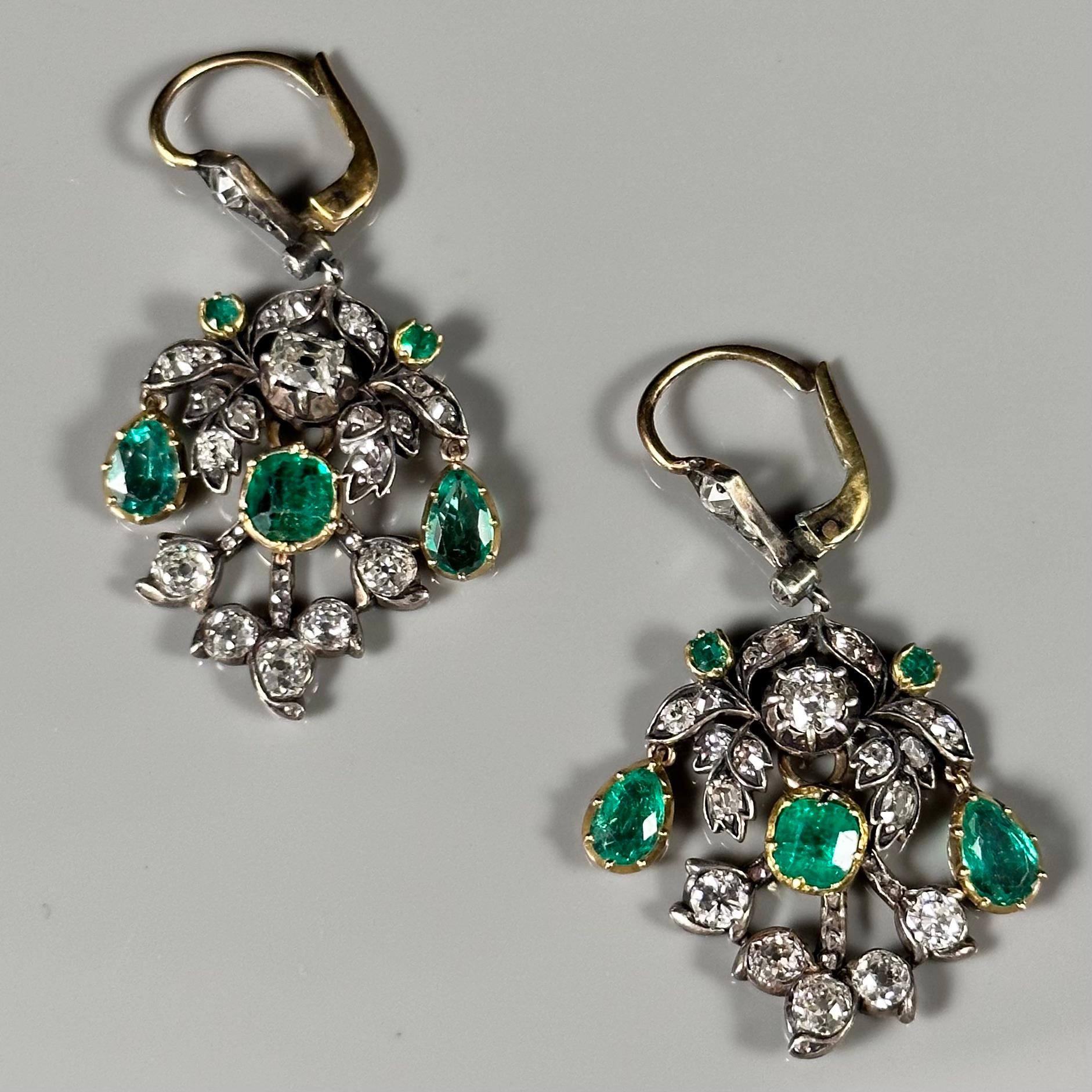 Antique La Belle Epoque Colombian emerald and diamond chandelier drop earrings in silver and yellow gold, circa 1915, possibly Portuguese, in fitted case by Reis & Filhos Porto jewelers. Each earring of an articulated floral and foliate design is