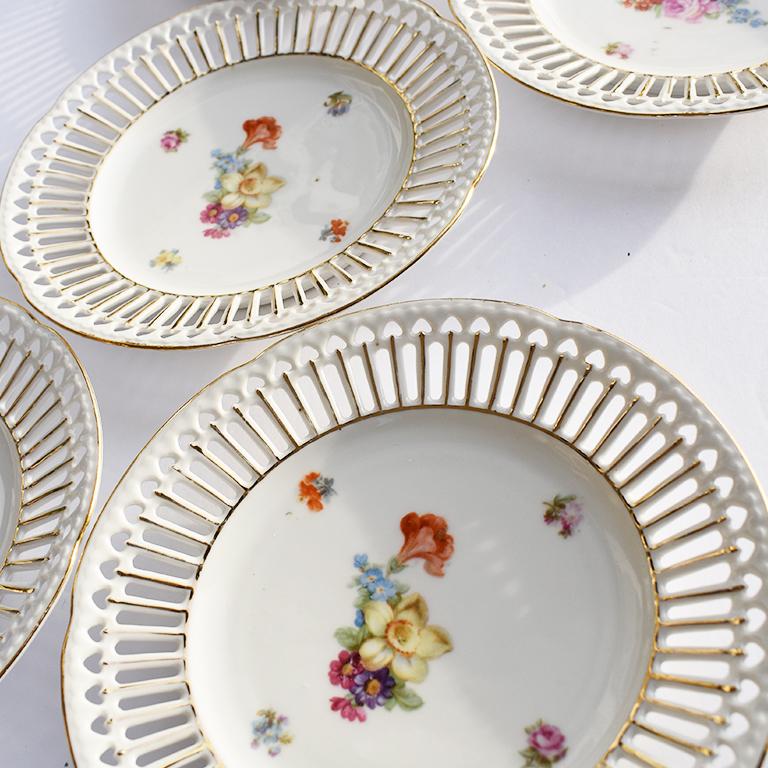 Set of 5 round reticulated floral plates. The beauties have a lace edge, made of rectangular piercings as well as heart-shaped piercings toward the ridge of the plate. Detailed round the edges as well as the entire border of the plates, gold paint