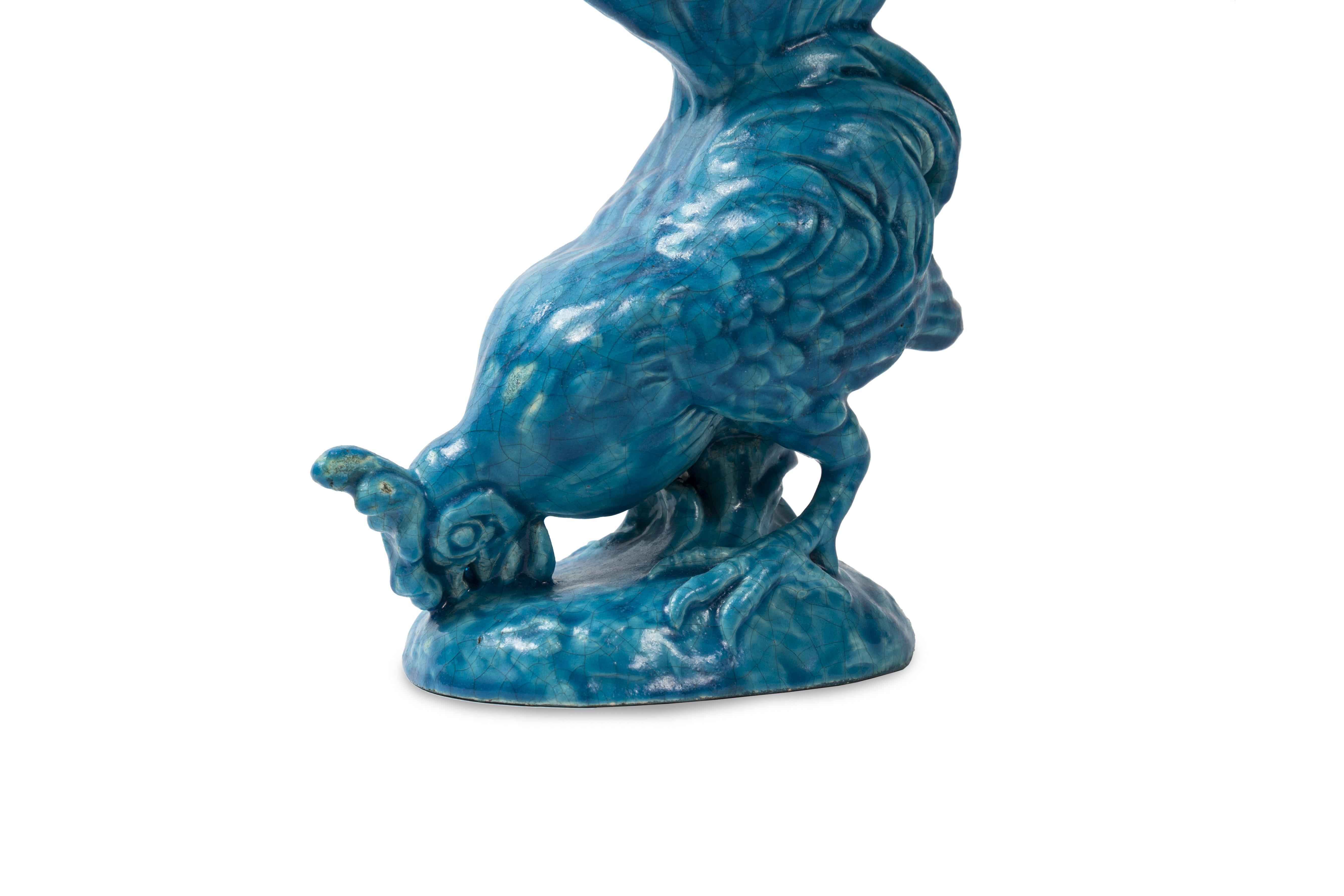 This bright blue earthenware rooster vase is signed Lachenal. This particular turquoise shade is reminiscent of the characteristic blue of Theodore Deck, with whom Lachenal was born before opening his own workshop.

This glazed earthenware rooster
