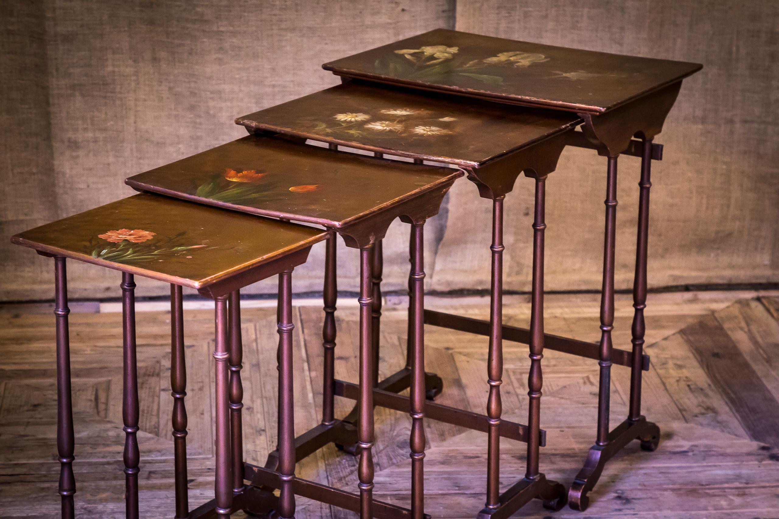 A lovely quartetto nest of tables in gold lacquer with painted tops depicting different flowers. The two larger tables have a worn patina as expected with years of use however, the smaller two have never been used and retain the original bright