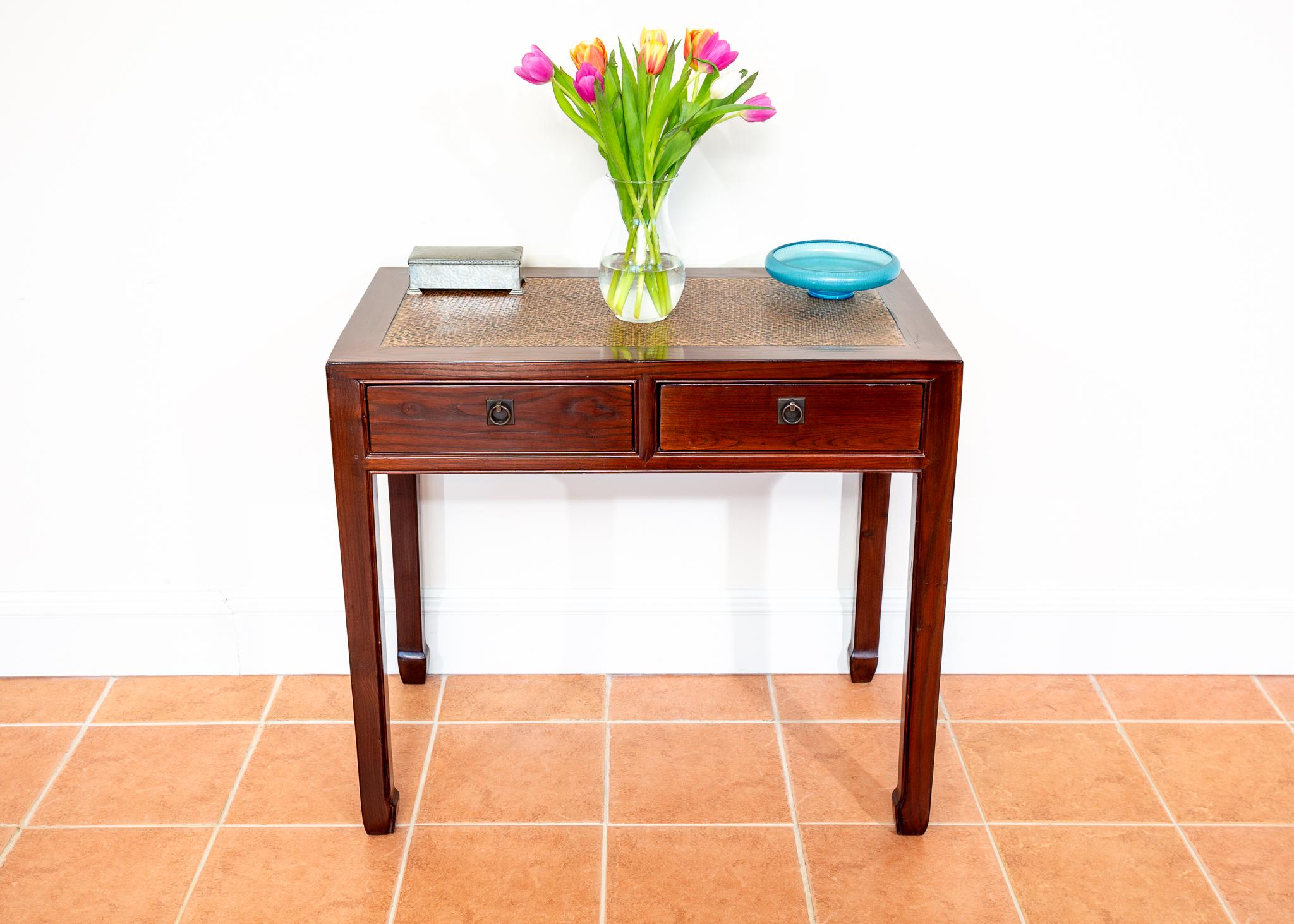 An extremely charming lacquered Chinese table in lovely antique condition. Traditionally crafted in China, most likely in the early Twentieth Century, this super and versatile piece makes a very stylish console table or a handy desk or bedroom table
