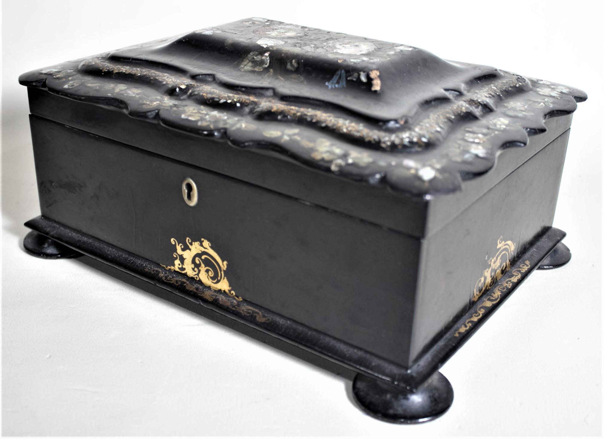 This large antique paper mâché and lacquered box is unsigned, but presumed to have been made in England in circa 1870 in the period Aesthetic Movement style. The box was made as a sewing chest, but could be adapted for other purposes such as a