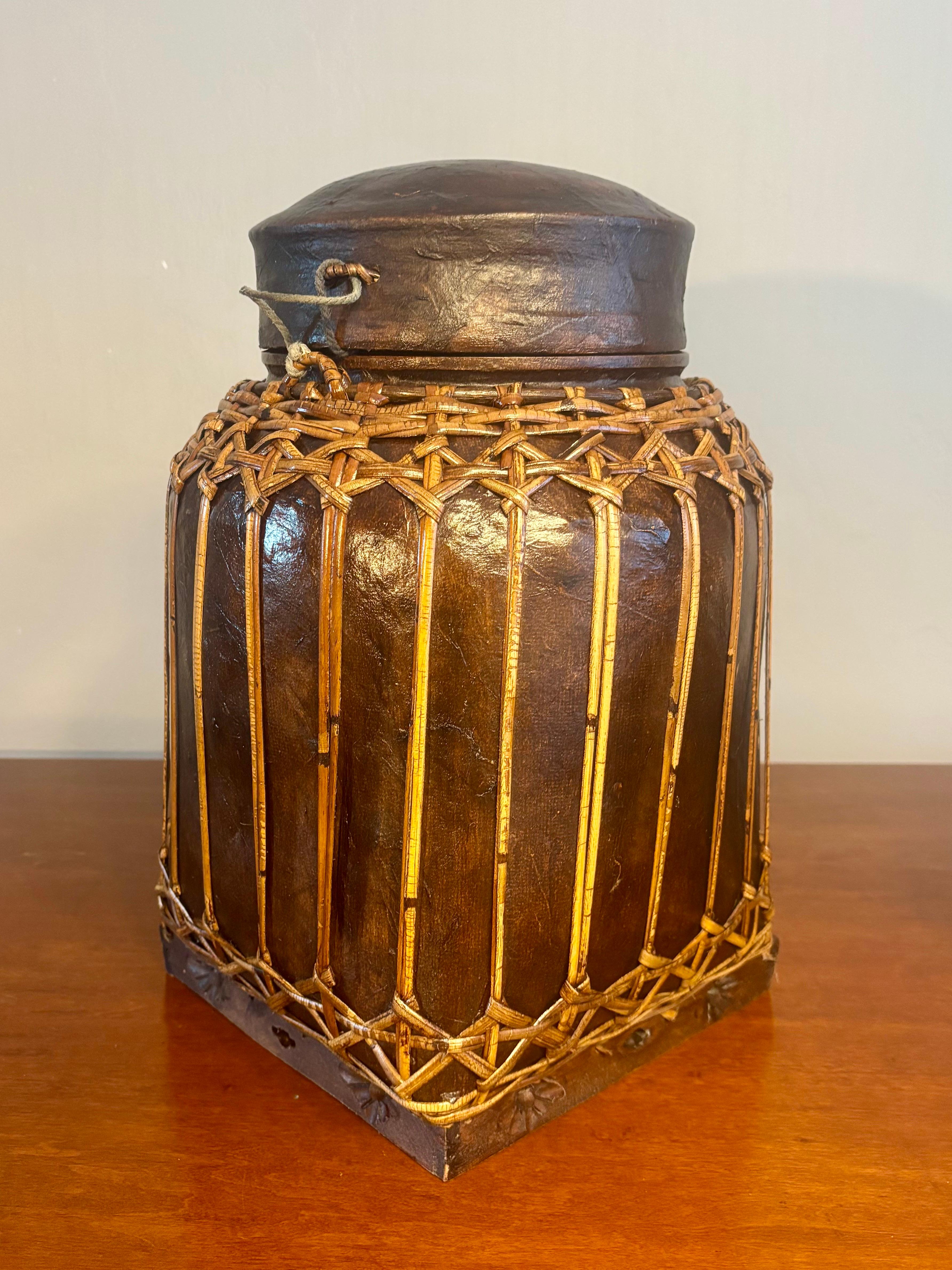 Charme Antiques, antico cesto di riso thailandese. Struttura intrecciata a mano con coperchio. Base originale in legno intagliato a mano. Il corpo e il coperchio sono realizzati in bambù intrecciato a mano. Poi coprirlo con la buccia di cocco per