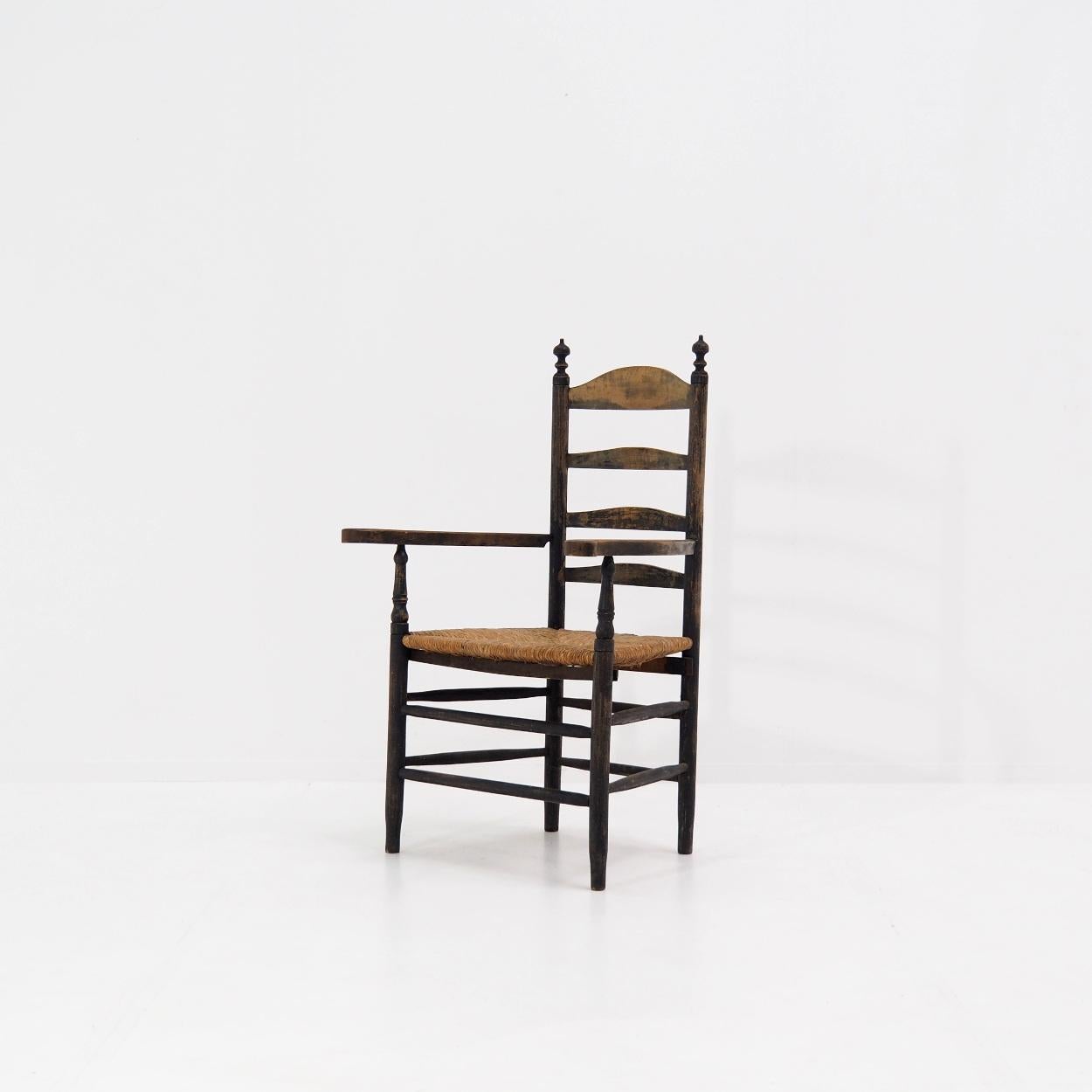 Antique ladder back chair from the Netherlands.

The chair still has its original patina from natural wear, with a paint that is a dark, almost black color. At the same time, the original wood is visible in other places.

The chair is made around