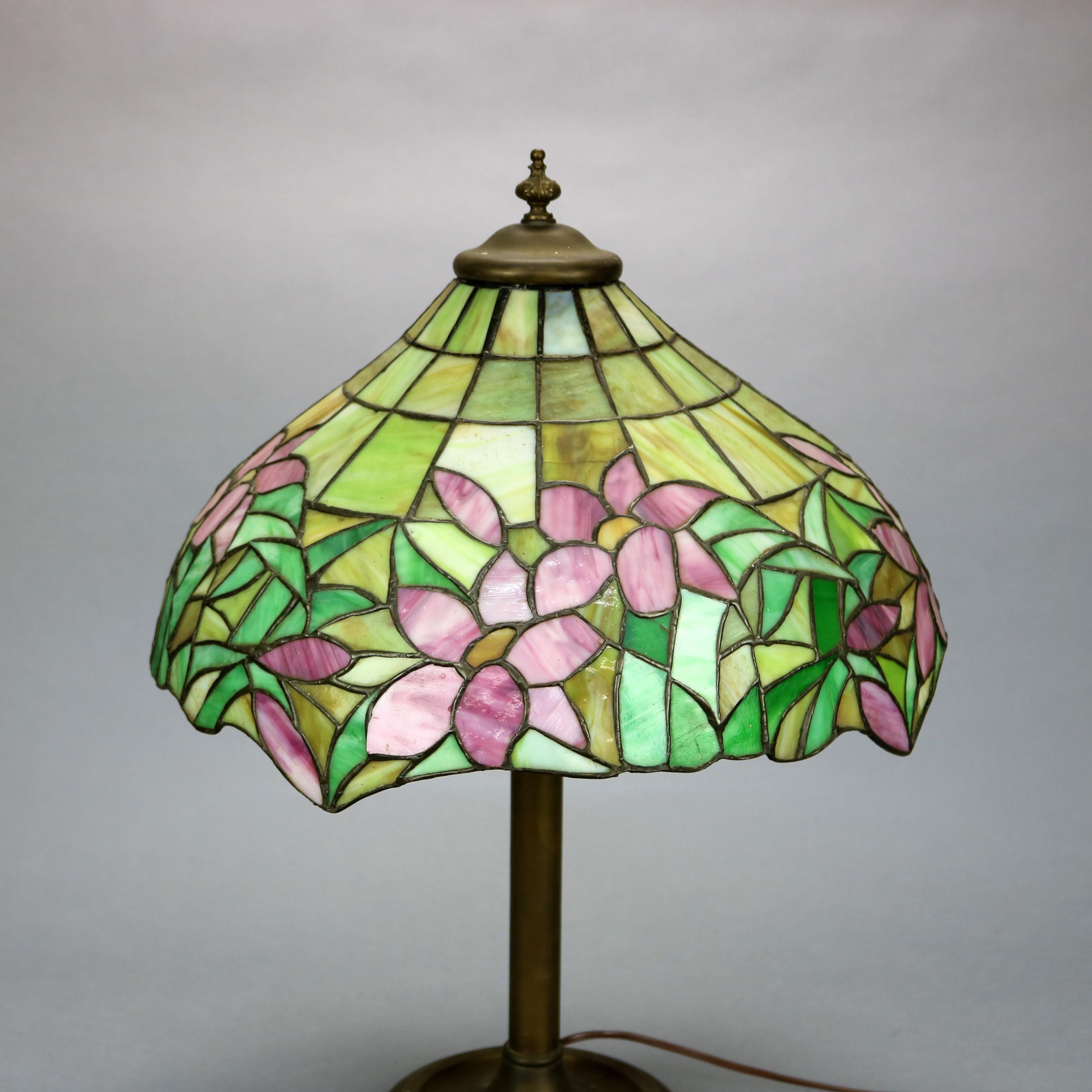 An antique Arts and Crafts table lamp by Lamb Brothers offers leaded mosaic glass parasol form shade with water lily pattern over cast double socket base, c1920

Measures: 24.5
