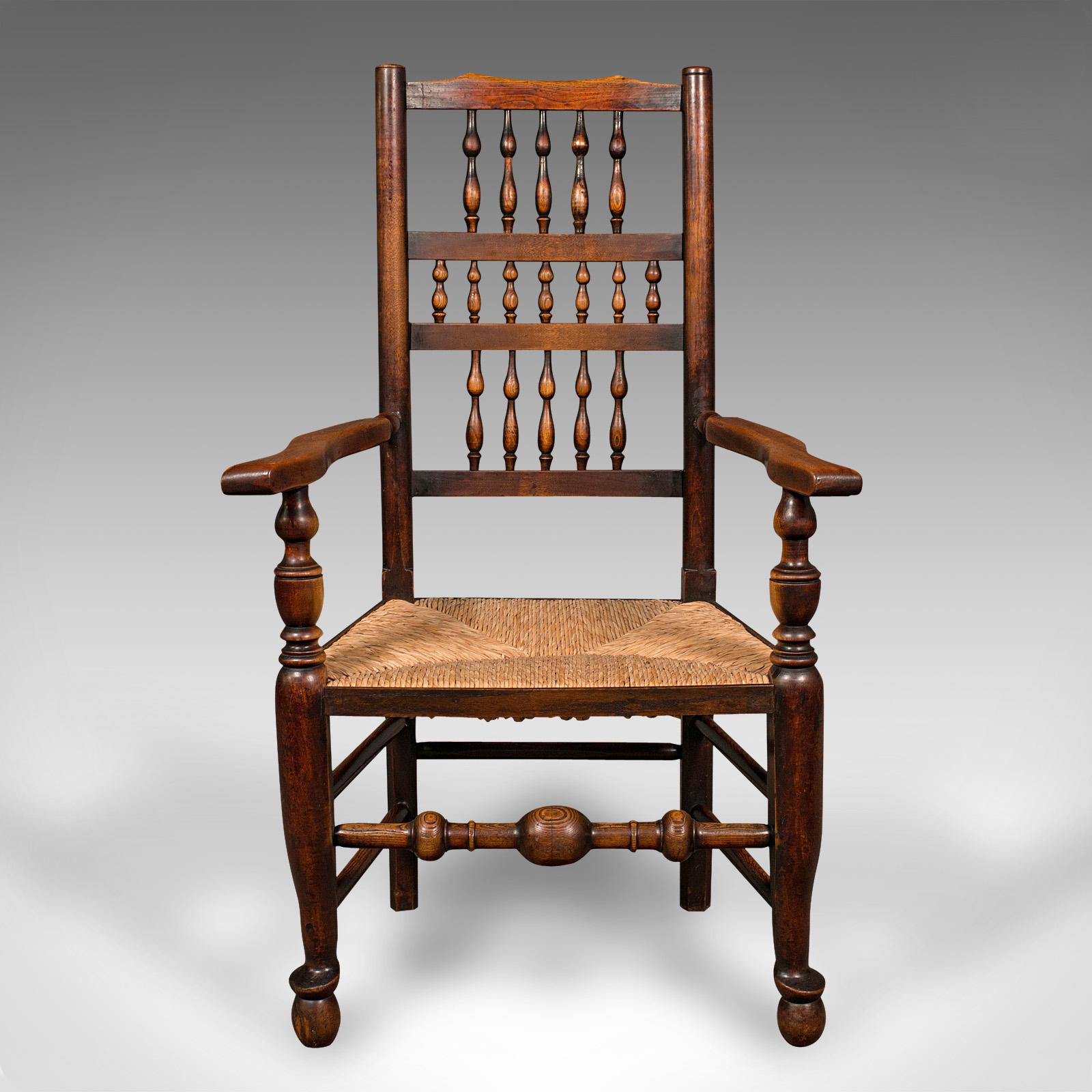 This is an antique Lancashire spindle back carver chair. An English oak and mahogany hallway elbow seat, dating to the early Victorian period, circa 1850.

Wonderfully traditional Lancashire taste with fine rush seat
Displays a desirable aged