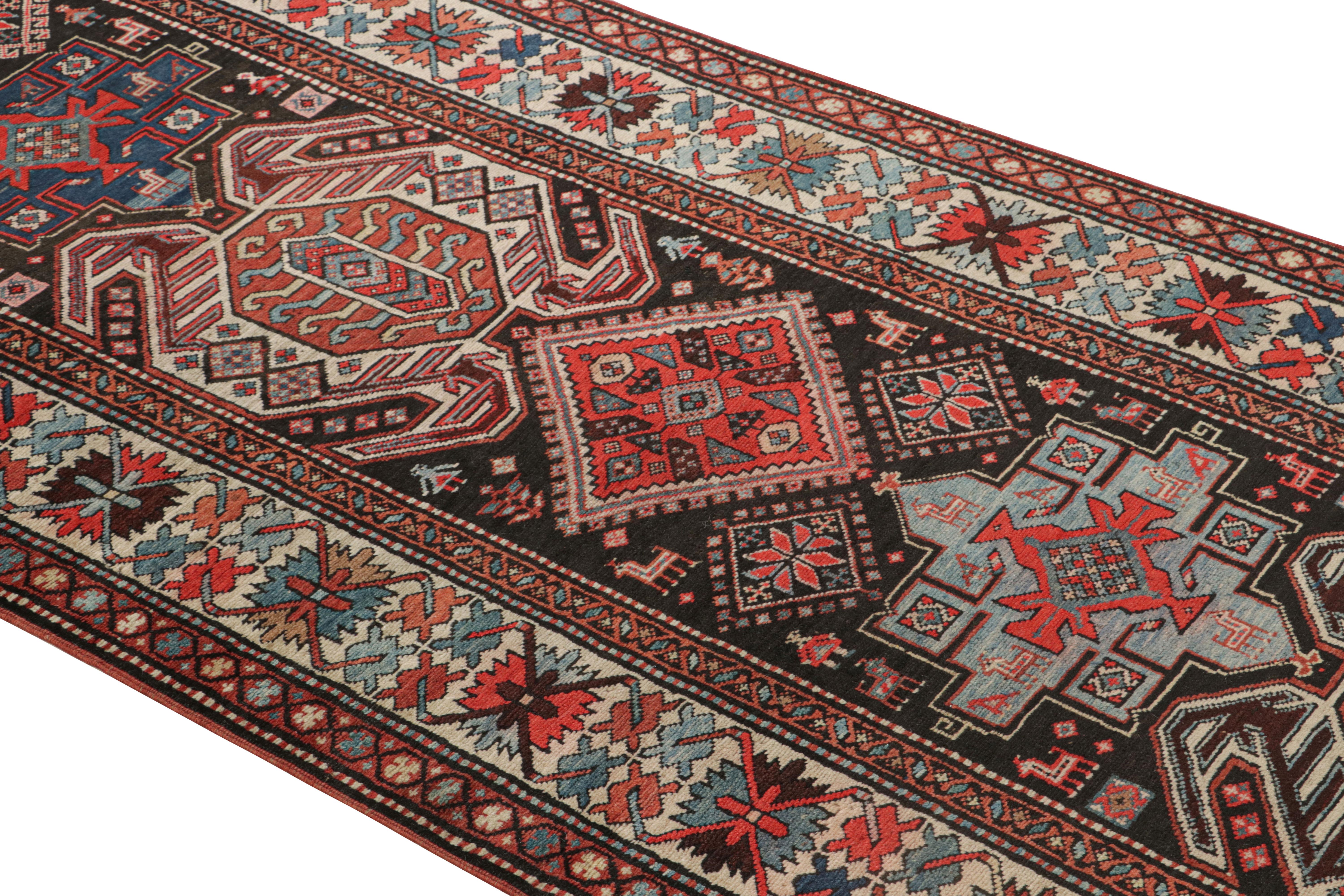 Originating from Russia between 1890-1900, this antique geometric rug featuring a Lankeran design, complemented by symbolic crab, human, and canine motifs among its varied symbols in rich burgundy red, black, and beige colorways. Hand knotted in