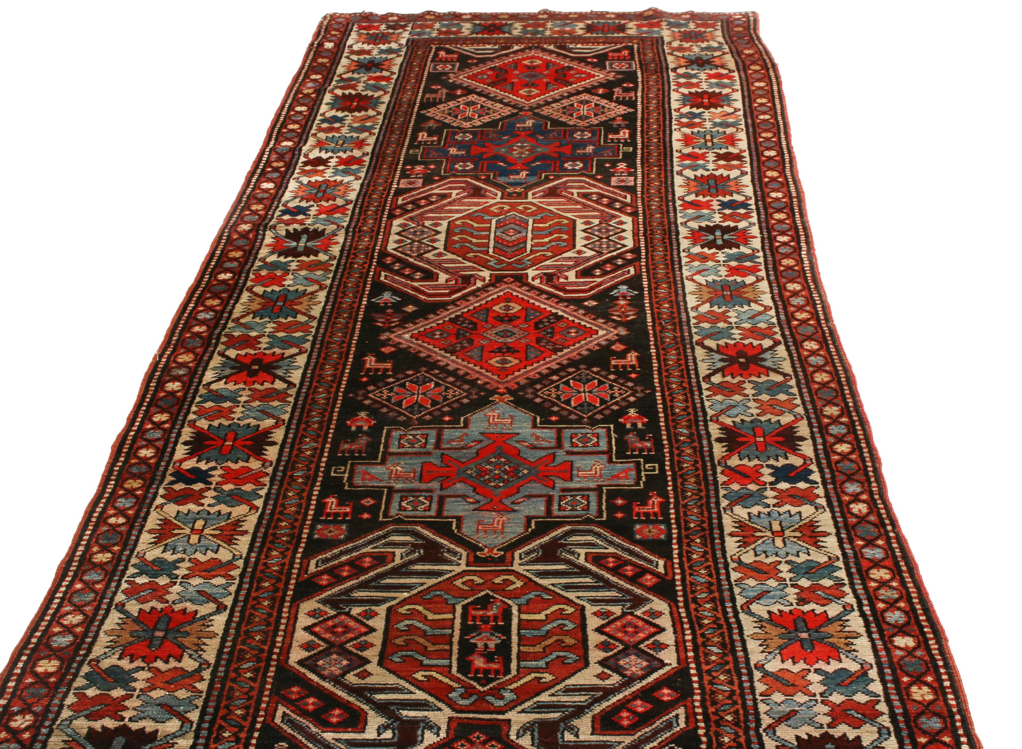 Originating from Russia between 1890-1900, this antique geometric rug featuring a Lankeran design, complemented by symbolic crab, human, and canine motifs among its varied symbols in rich burgundy red, black, and beige colorways. Hand knotted in
