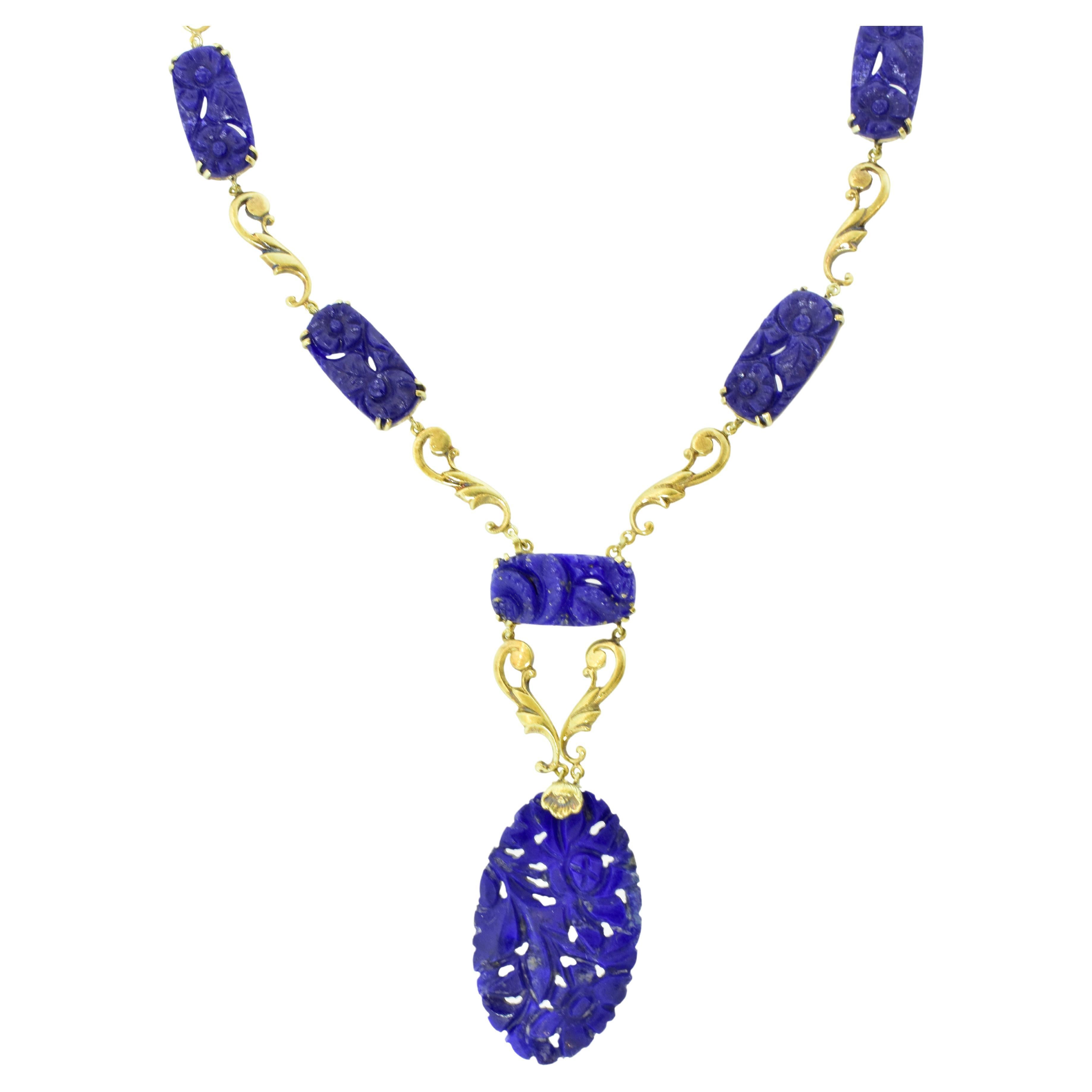 Antique necklace of finely carved and pierced  natural vivid blue lapis.  This handmade gold necklace is in total 17 inches long.  The pendant portion is 3 inches in length, and the necklace of punctuated early gold period scrolls and fine lapis