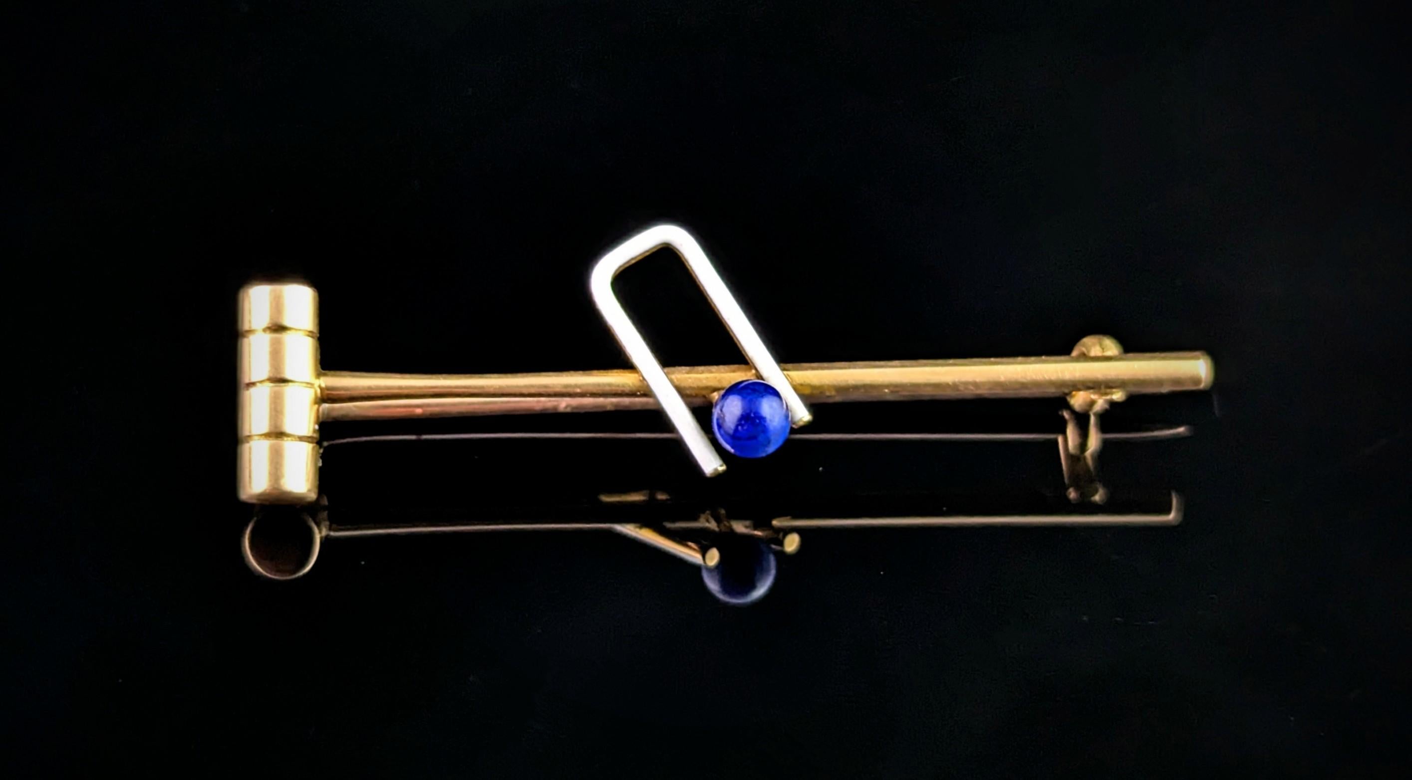 You can't help but be charmed by this very well designed antique Edwardian era croquet brooch or pin.

Designed as a croquet mallet, ball and hoop the mallet is crafted from rich 15ct gold, the hoop is realistically enamelled in crisp white and the
