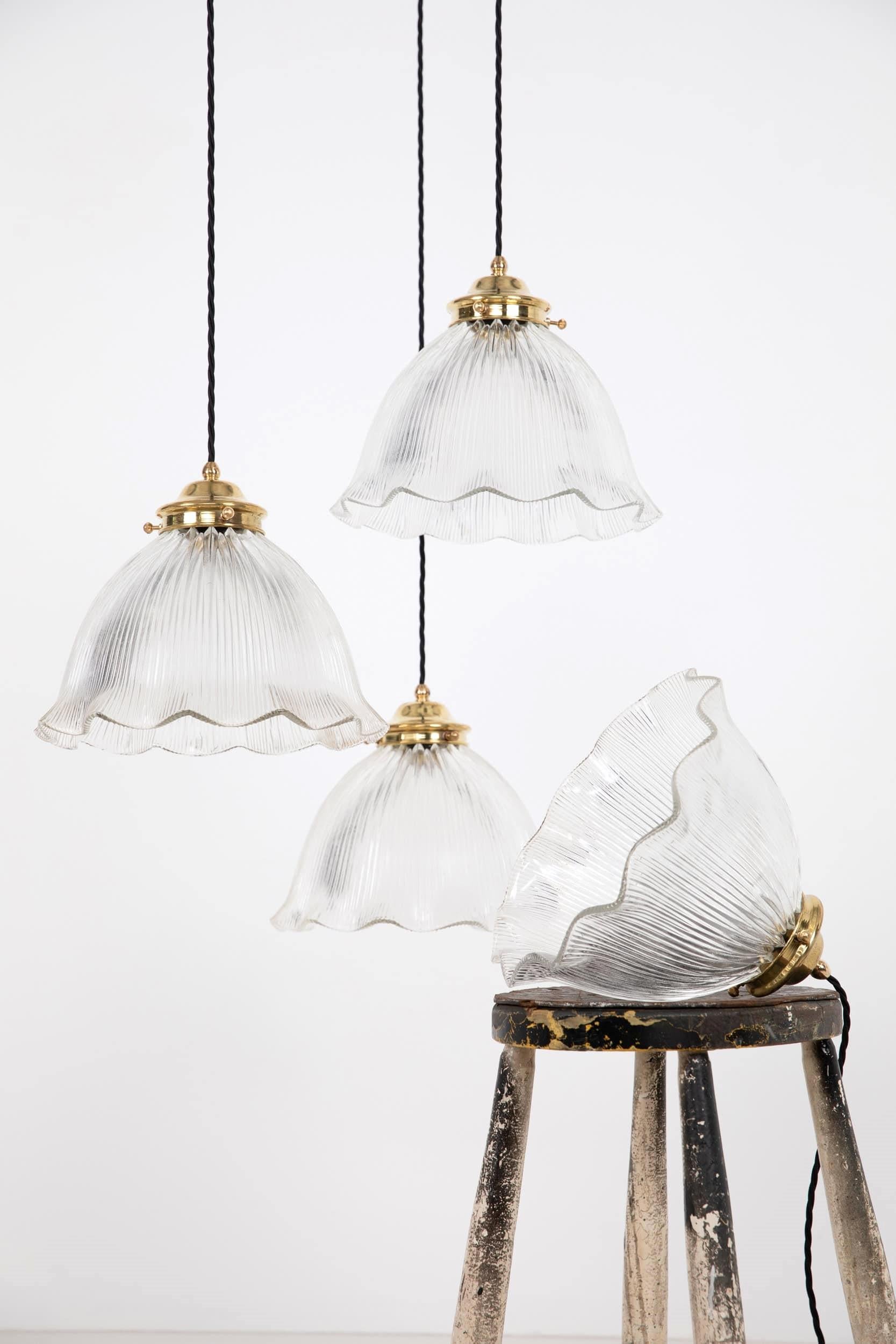 

Lampade a sospensione in vetro prismatico a balze di forma elegante realizzate in Inghilterra. c.1920

Di forma molto più grande del solito, paralumi in vetro prismatico chiaro smerlato con gallerie in ottone lucido. Non è un Holophane stampato,