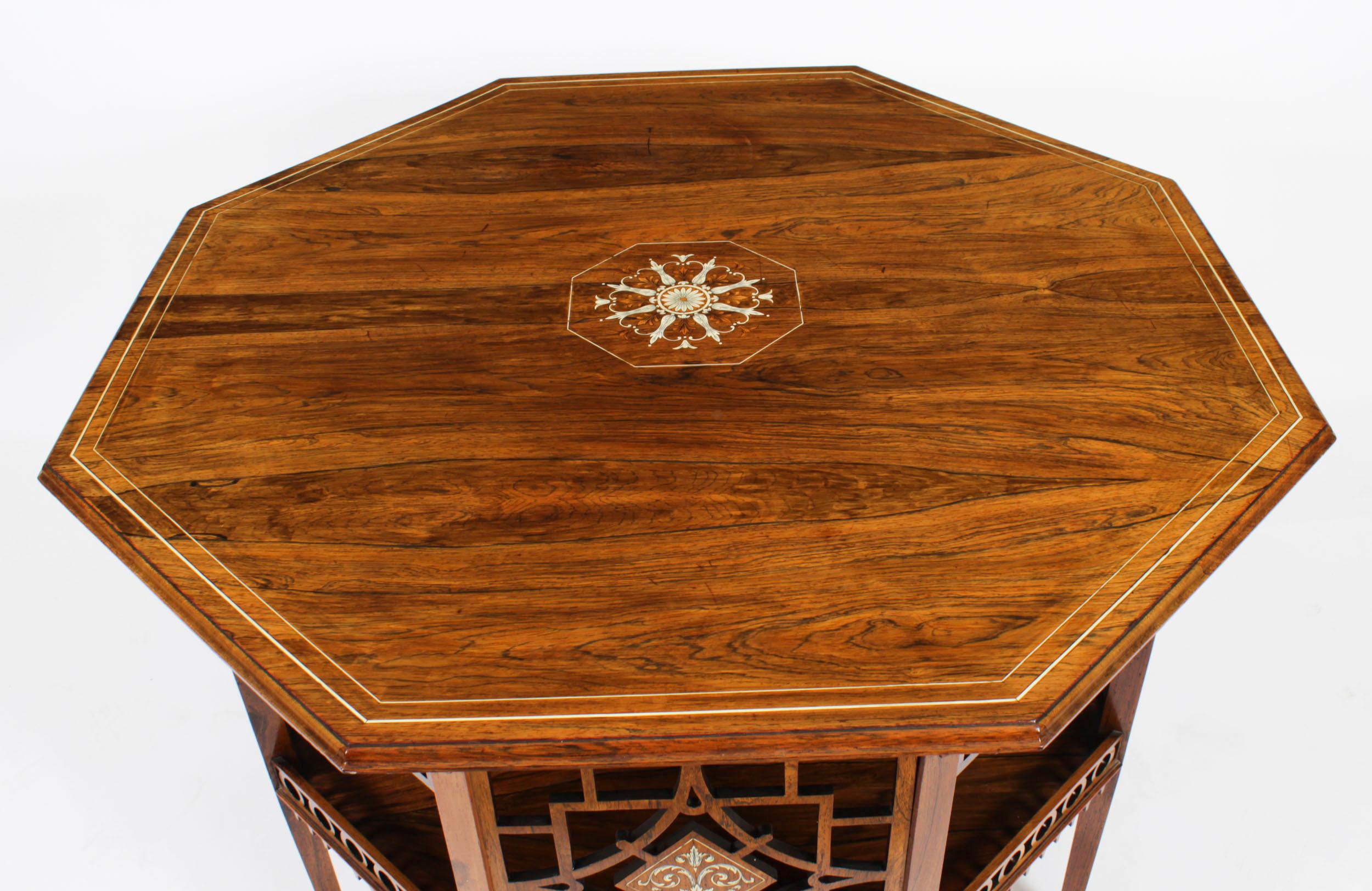 This is a beautiful English antique late Victorian Gonçalo Alves octagonal centre table, circa 1890 in date.
 
The banded strung top is beautifully centred by a floral marquetry rosette over an undertier with openwork side panels with marquetry