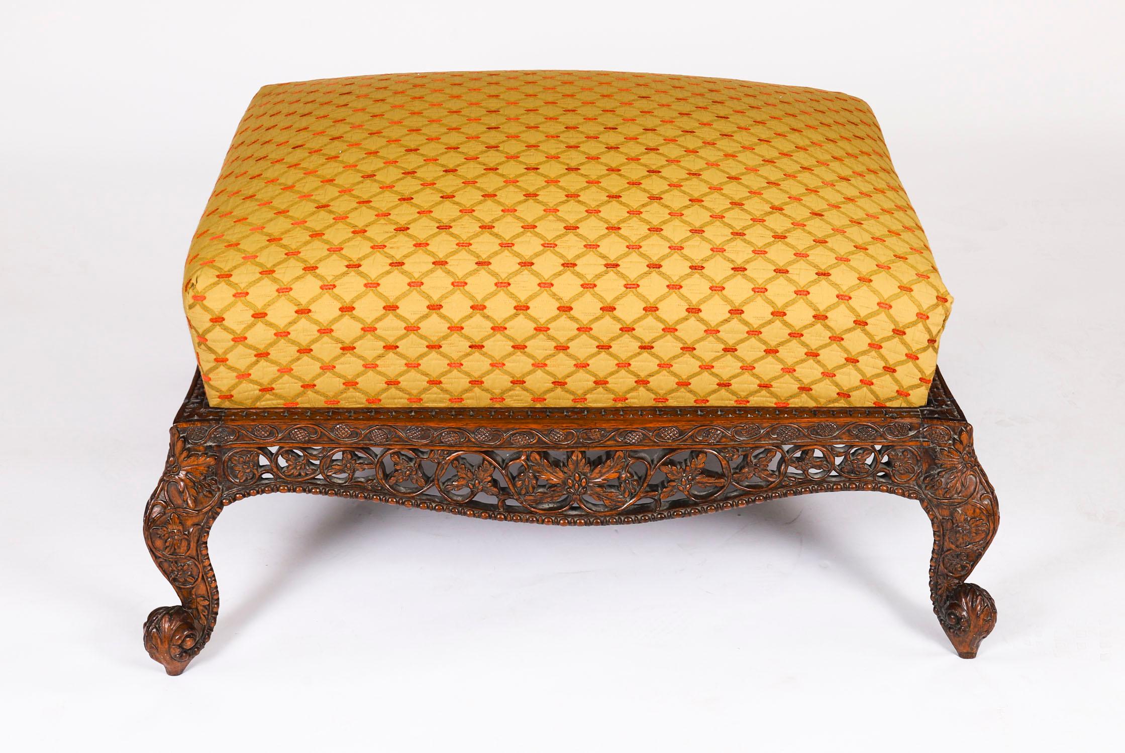 Se trata de una gran otomana/taburete angloindio de caoba finamente tallada, de principios del siglo XIX.
 
La otomana, de forma rectangular, presenta una profunda base magníficamente tallada, decorada con volutas y ornamentos foliados y florales,