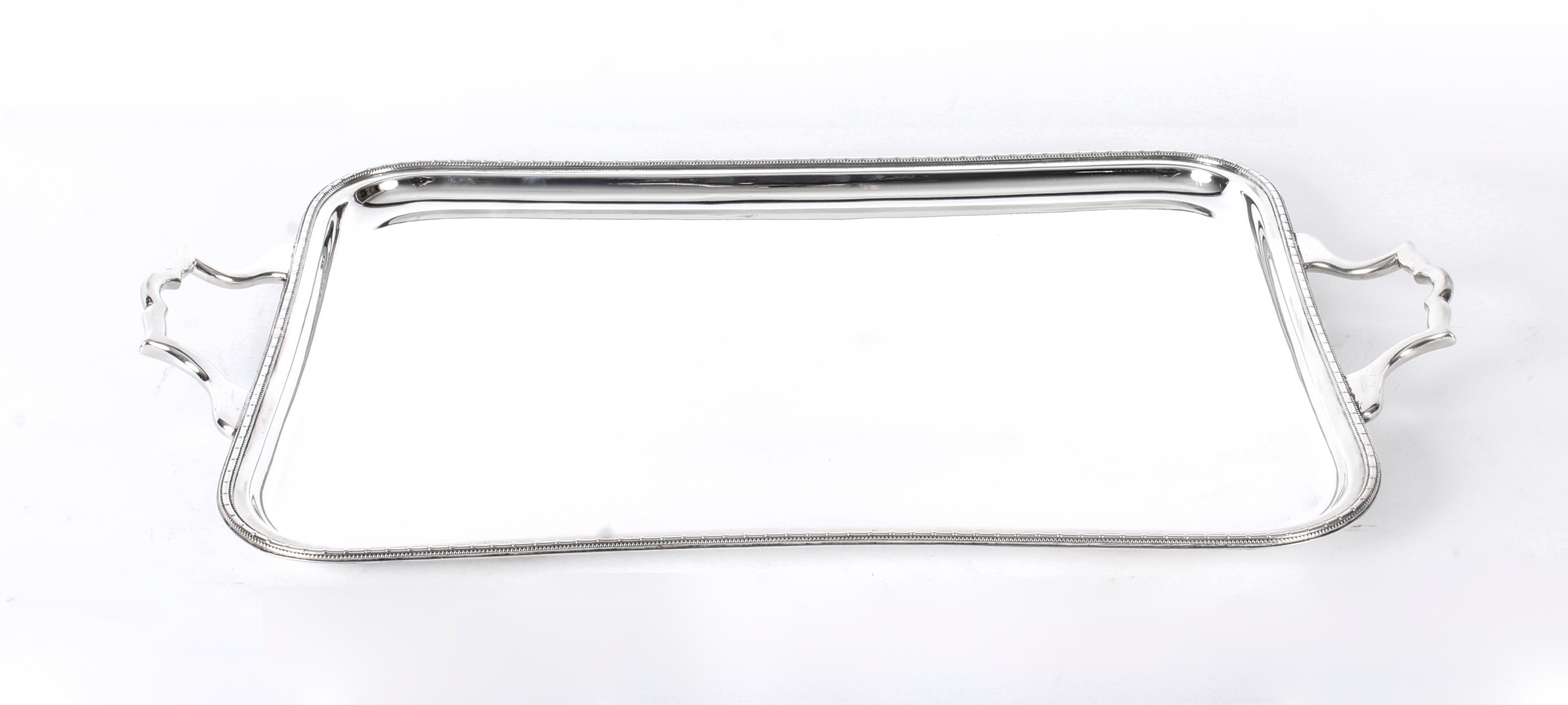 This is a lovely large antique English Art Deco silver plated butlers tray, circa 1930 in date and bearing the crossed swords makers mark.

This large rectangular silver plated tray features a slight central incline with a medium inset decorative