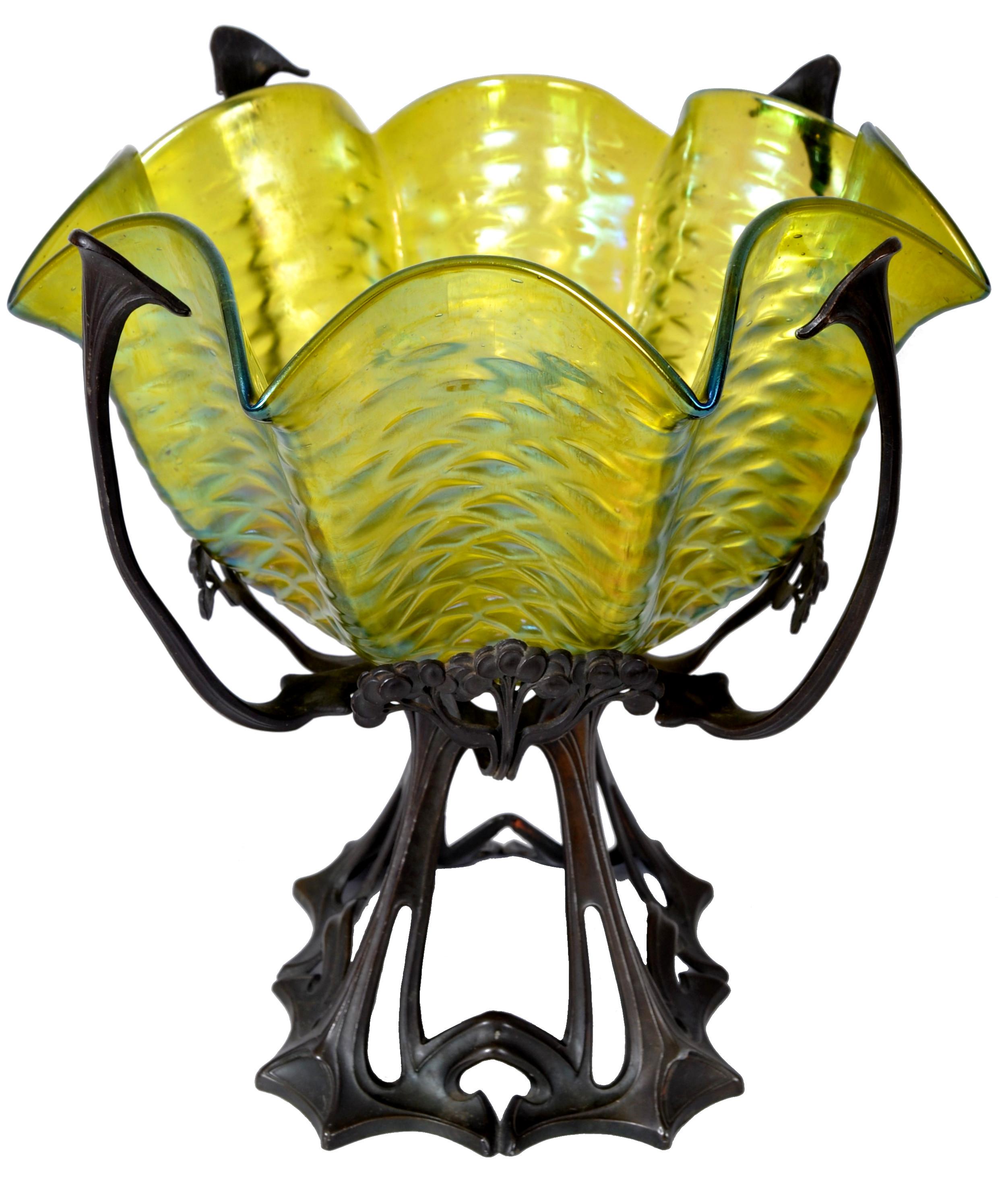 A good and large hand blown Loetz glass bowl with bronze stand circa 1900. The hand-blown chartreuse colored iridescent glass bowl of wavy octagonal form and having a textured 'trailed' glass design. The bowl is housed in the original bronze metal