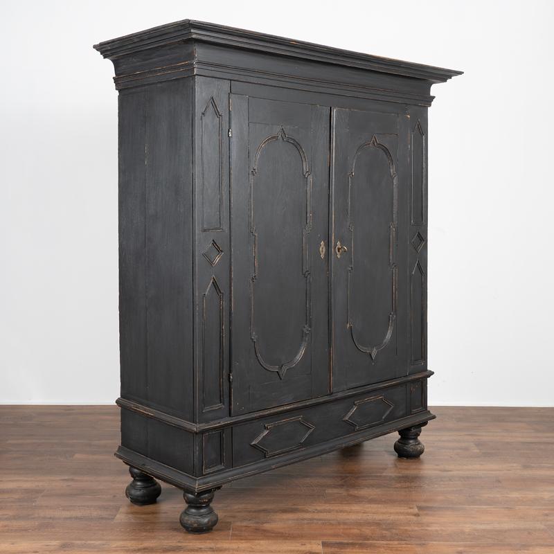 This massive oak armoire is even more impressive due to the baroque carving that adds depth to the paneled doors. There are two lower drawers and the entire armoire rests on large bun feet. Please examine close up photos to appreciate the details