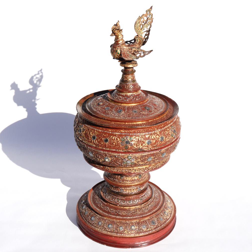 Antique Large Burmese Hsun-ok, a ceremonial food offering box to present to a monastery, a covered cylindrical stupa box form decorated in Mandalay style with mirrored glass, raised thayo lacquer in a foliate scroll design and gold leaf