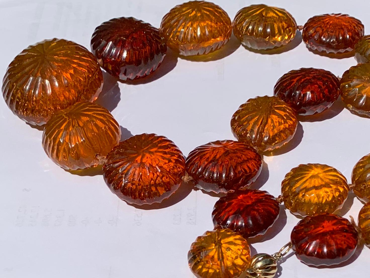  Exceptional and unique. The central amber bead measures an impressive 50mm in diameter with the necklace composed of twenty five graduated round disk shaped natural translucent amber beads, each with sun ray facets on both sides, wonderful old