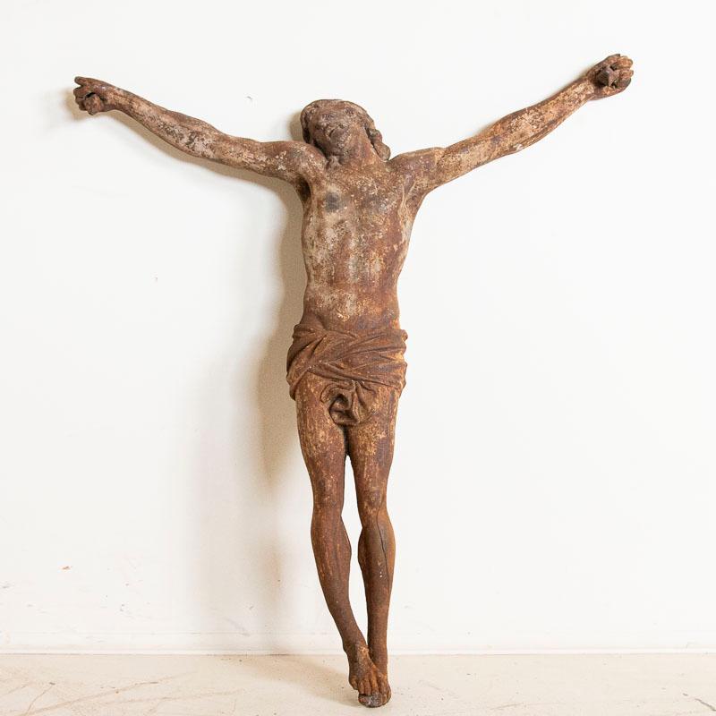 This impressive antique cast iron Christ crucifix was long ago separated from its original cross. The weathered, aged patina reveals rust all over, in addition to wear and distress adding somehow to the powerful impact of the suffering Christ