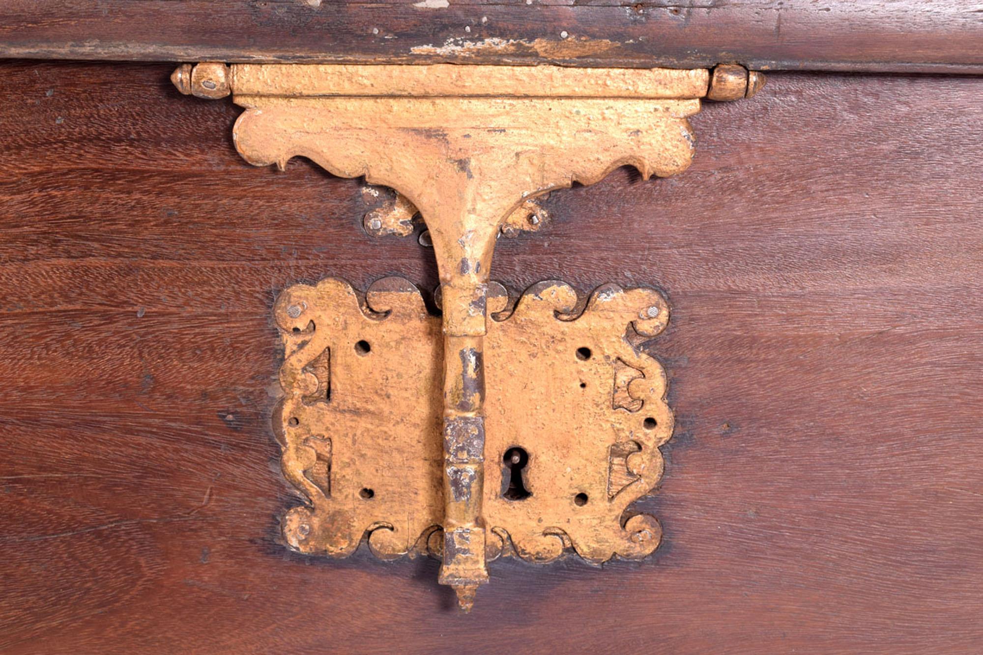 A large, stately chest crafted from sucupira wood, known for its durability and rich, deep coloring. Originating from the 19th to 20th century, the chest exudes a sense of historical significance and robust antiquity. The wood's surface displays a