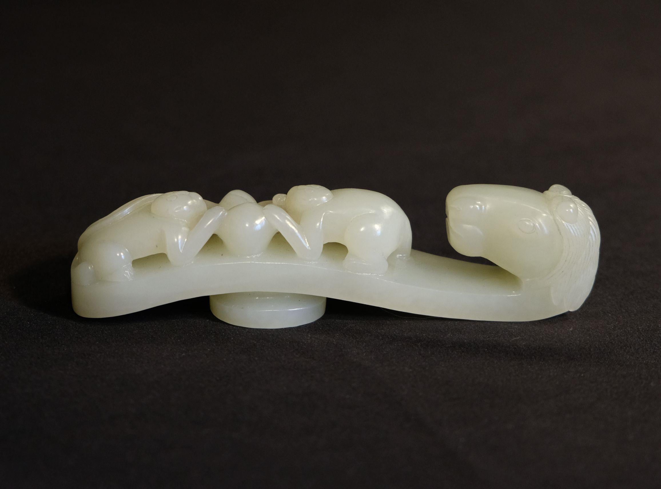 A large Chinese carved Hetian White Celedon jade buckle, a beast head with two monkeys on the lower part and two peaches in the middle, depicting the meaning of long life with a successful political career.

Dimensions:

Height: 4.75