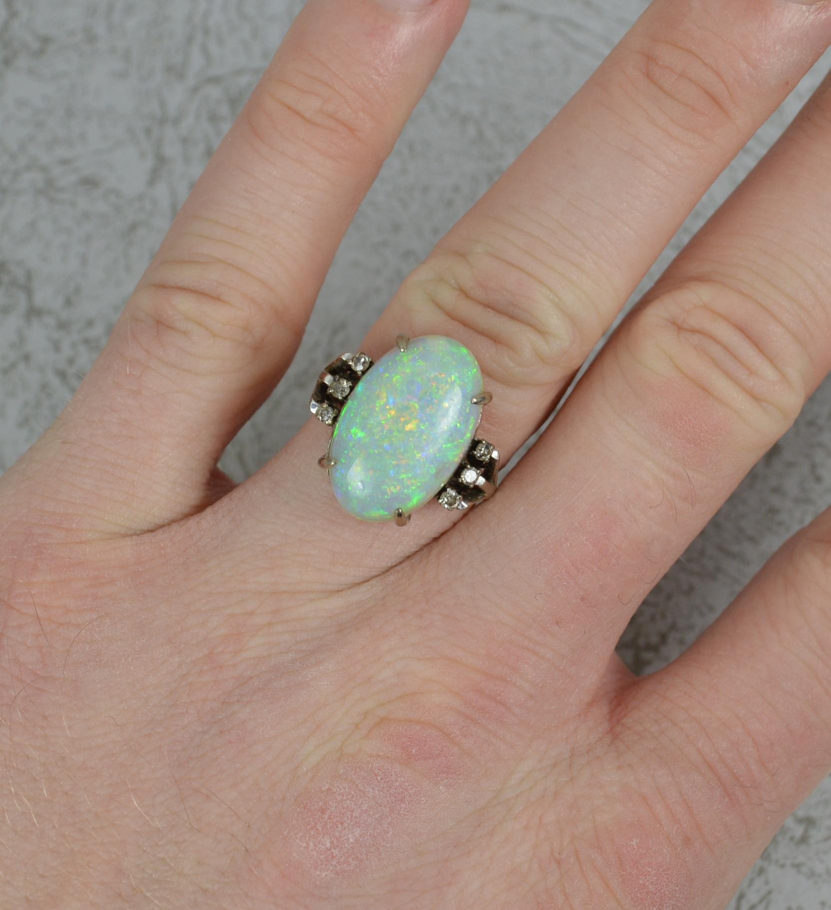 A stunning antique ring, circa 1910-20.
Solid 18 carat white gold example. Split shoulder design with a fine scroll under cage.
Set with one single, large, oval shaped opal in four claw setting. A very colourful and bright example. 10mm x 18mm