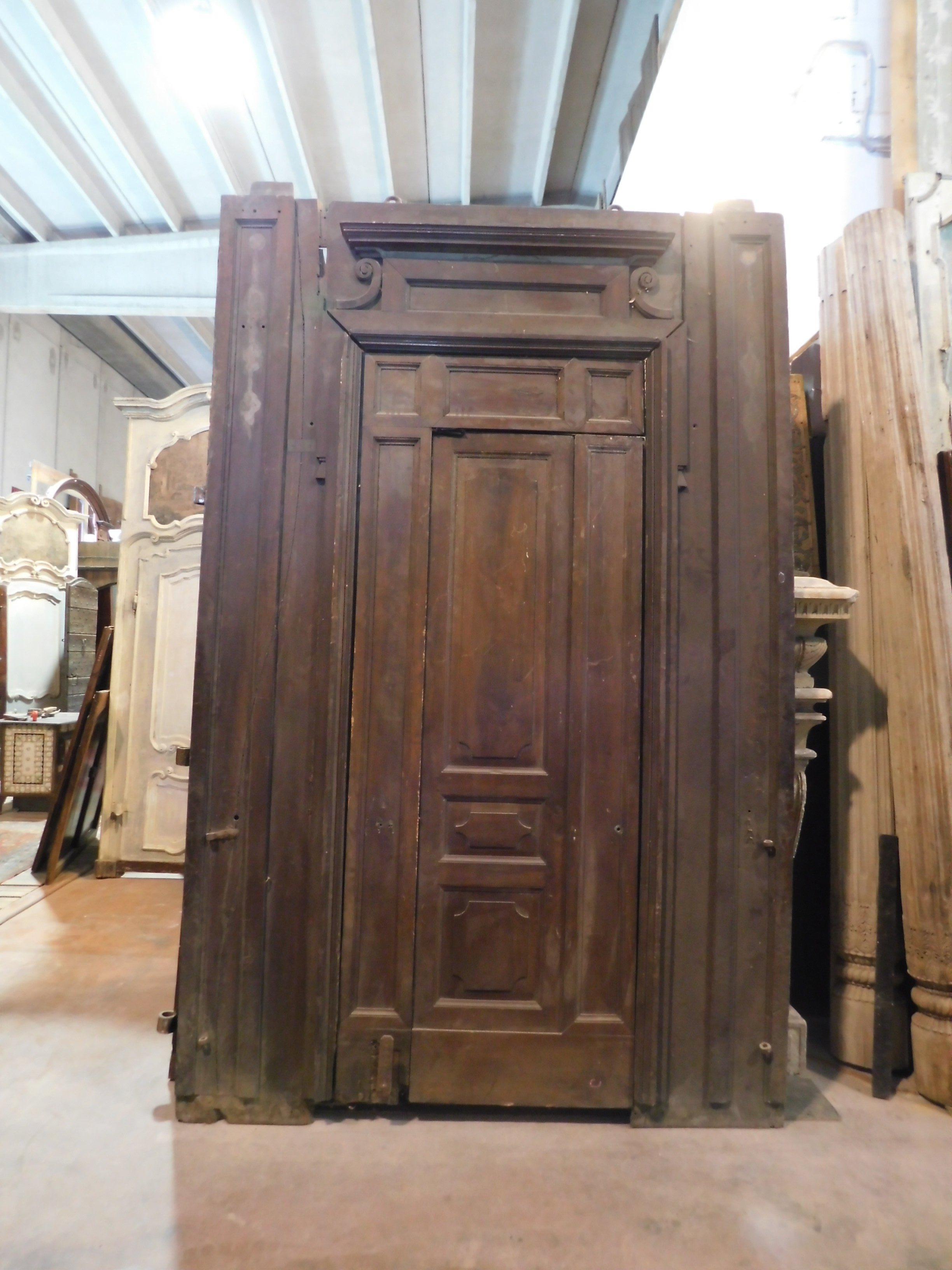 Ancienne grande porte en bois de noyer, avec diverses ouvertures telles qu'une petite porte intérieure, et voulant (en changeant les charnières) une deuxième porte intérieure plus grande, voire des charnières pour ouvrir toute la porte au passage de