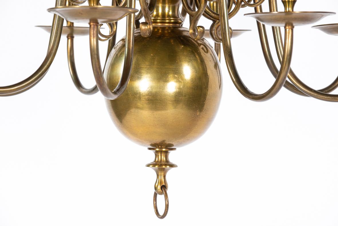 This impressive brass chandelier with eight arms is a heavy ball chandelier, crafted around 1900. Its classic design is defined by the large, heavy ball at the base, which ensures the fixture hangs steady and stable, even if set in motion. This type