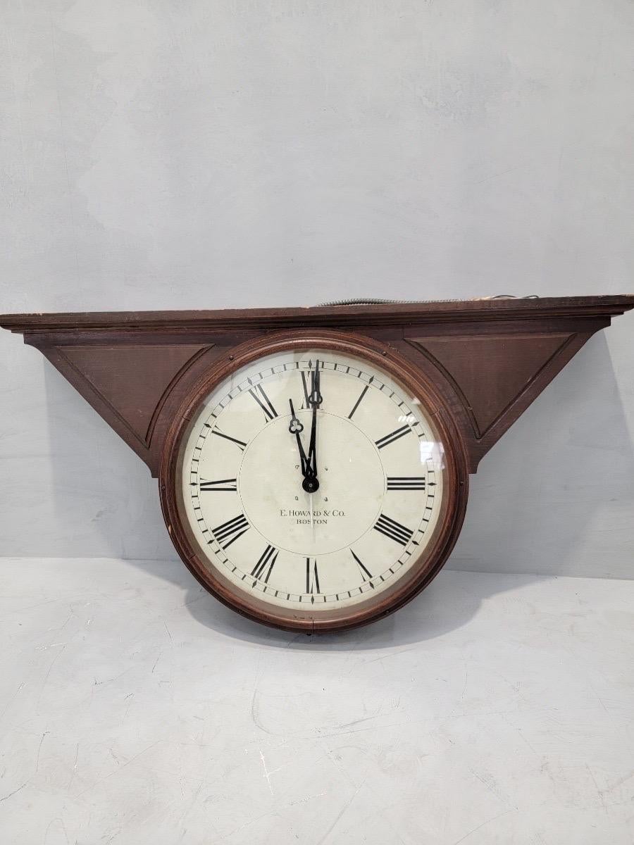 Grand modèle E. Howard & Co. Horloge de banque en chêne à double face et à montage par le haut 

Howard & Co. est une entreprise horlogère renommée qui a vu le jour à Boston au milieu du XIXe siècle. Cette pièce d'horlogerie en verre avec des ailes